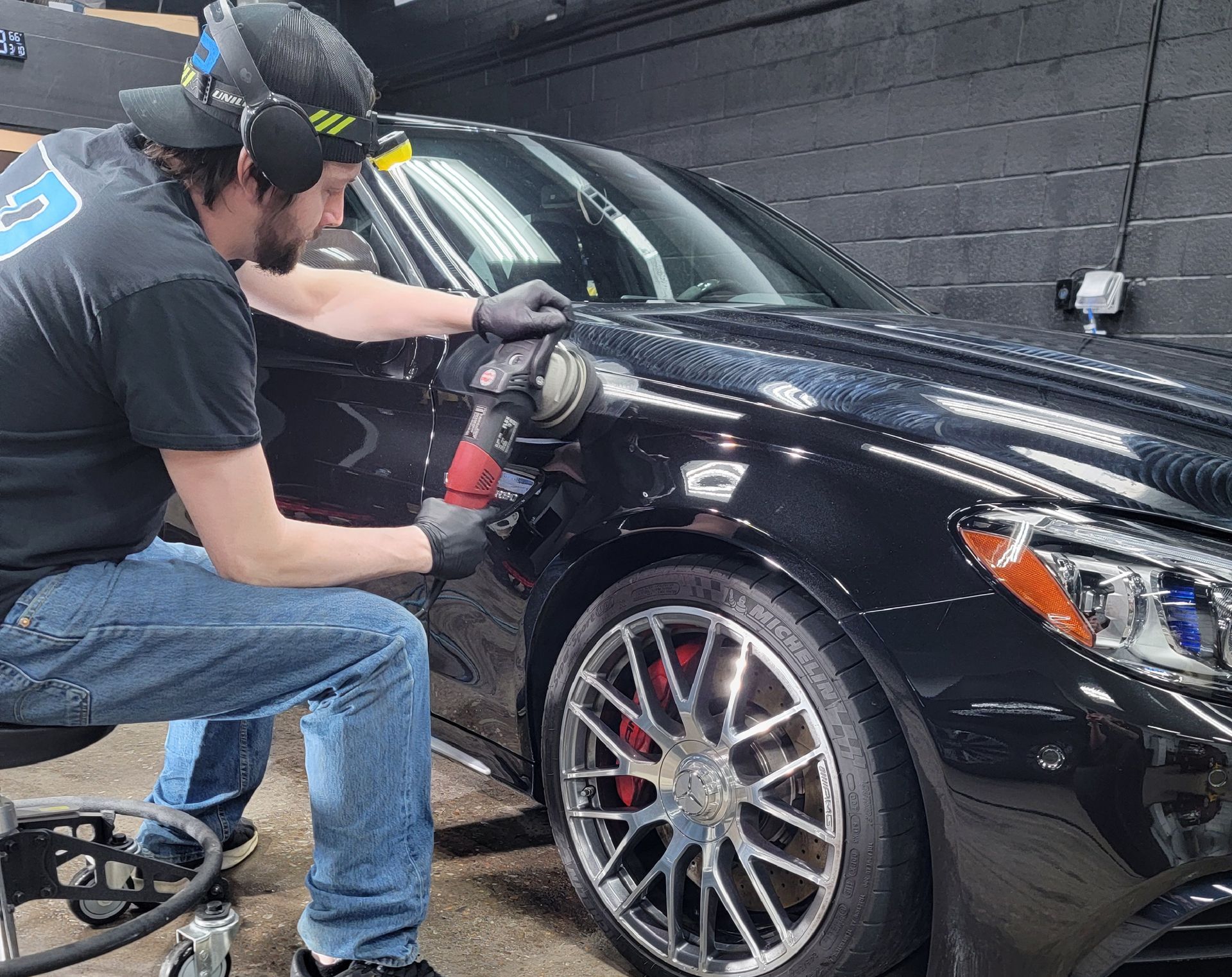 A man is applying window tinting to a car door