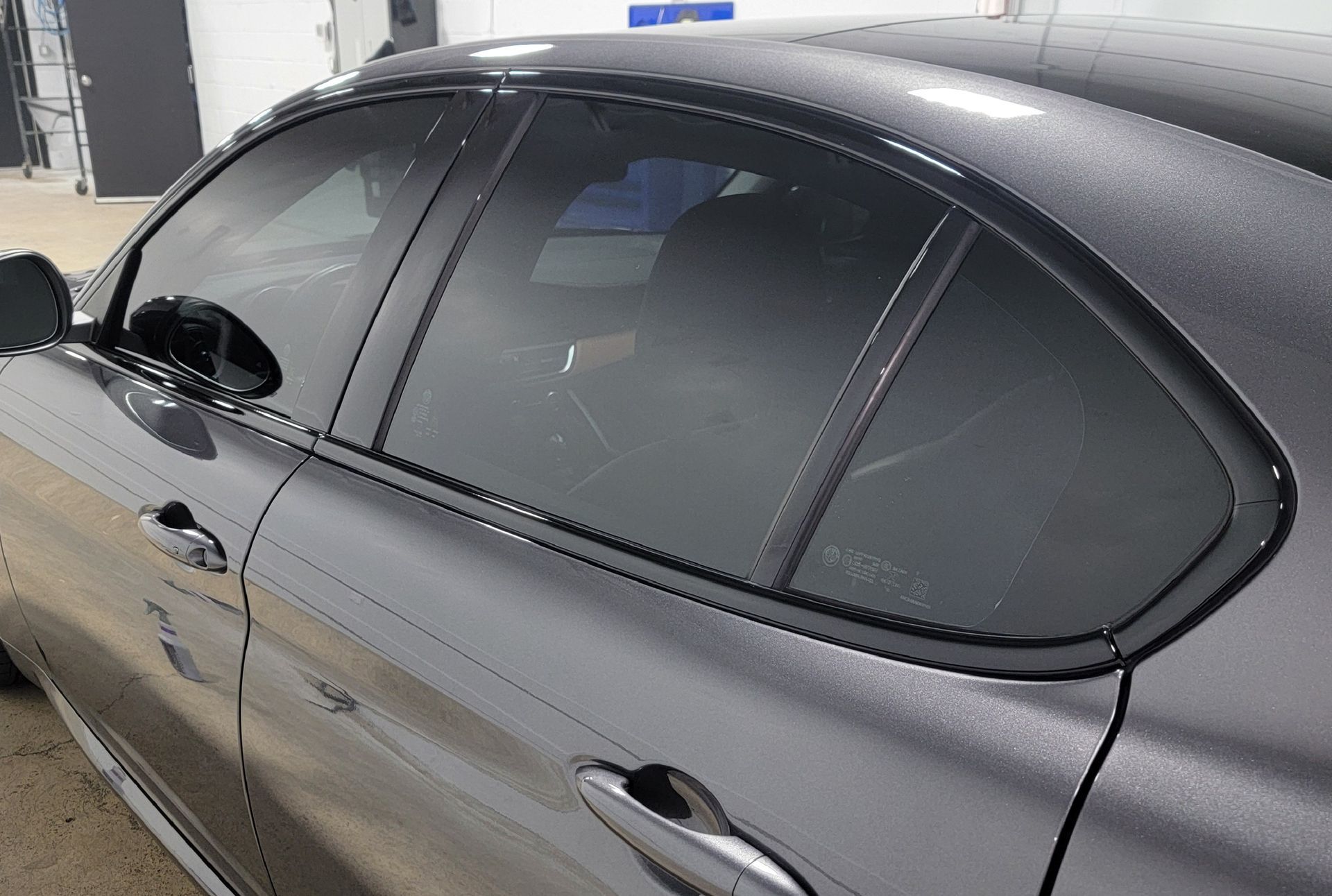 A man is applying window tinting to a car door
