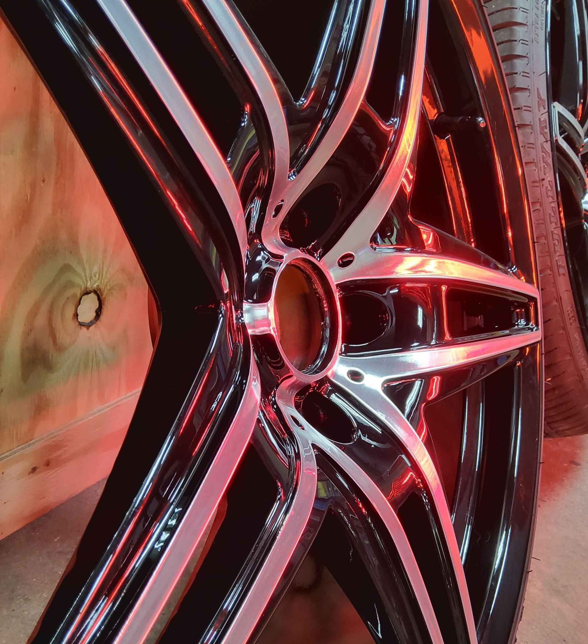 A close up of a car wheel with a red light behind it