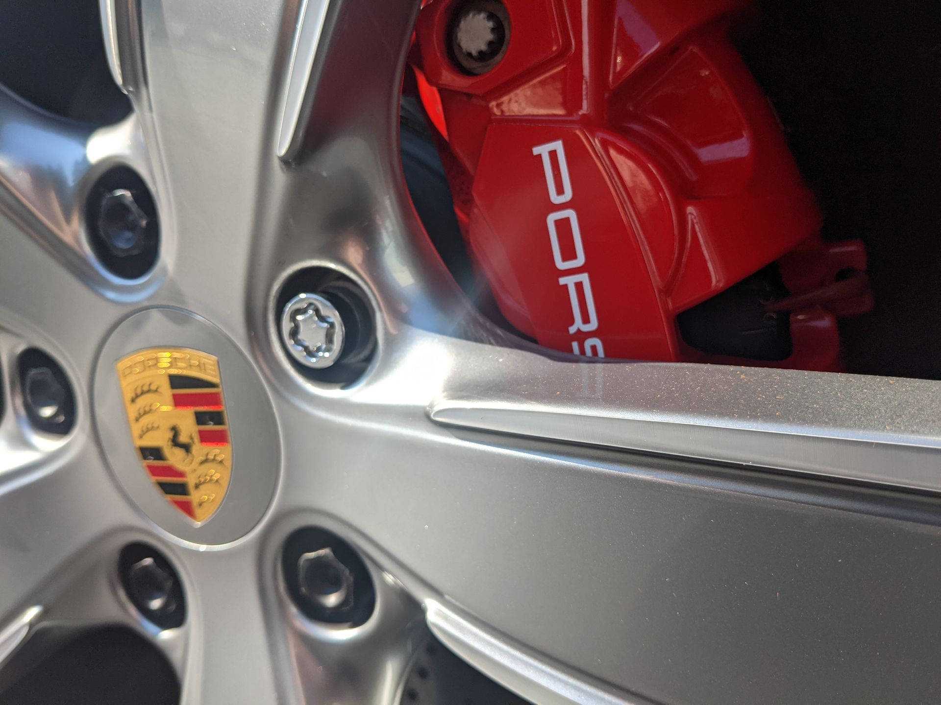 A close up of a porsche wheel with a red brake