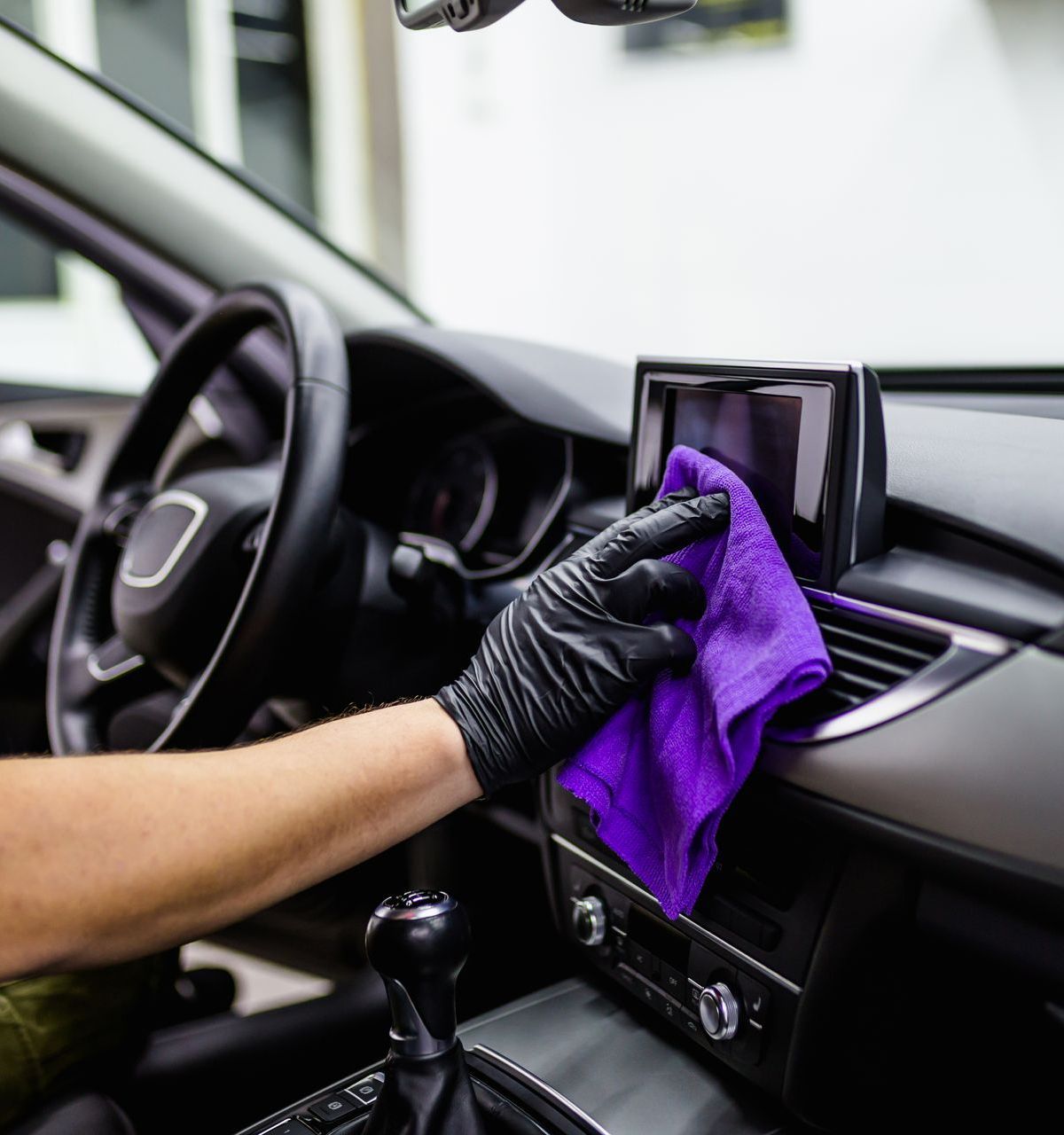 A man is applying window tinting to a car door