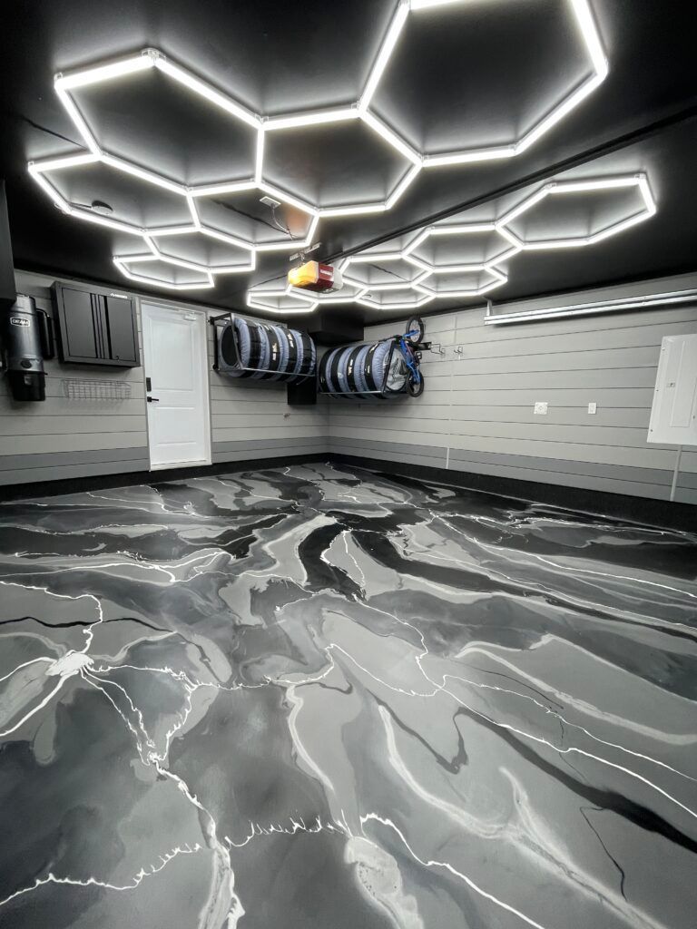 Garage with hexagon-shaped lights, metallic epoxy floor, and car detailing supplies.