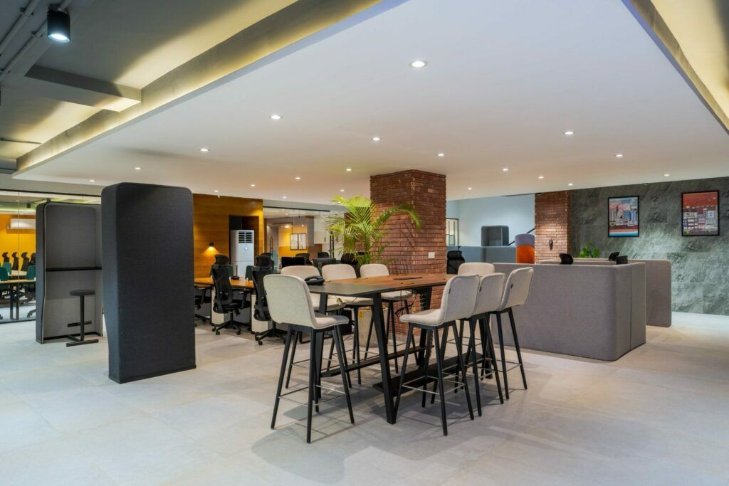 Open office space with a high table, chairs, and several work stations.