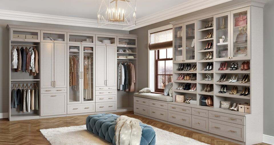 Spacious walk-in closet with built-in shelving and hanging rods. Includes a window seat, and ottoman.