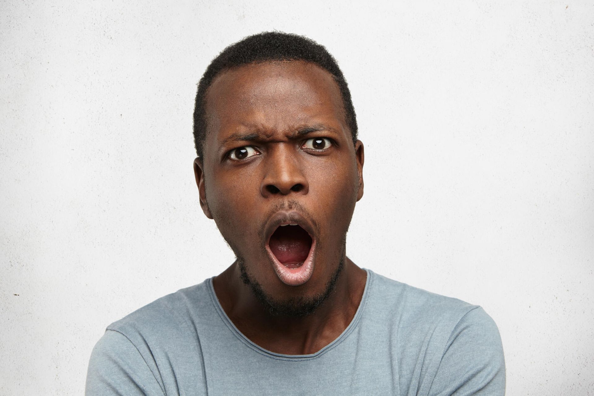 A man is making a surprised face with his mouth open.