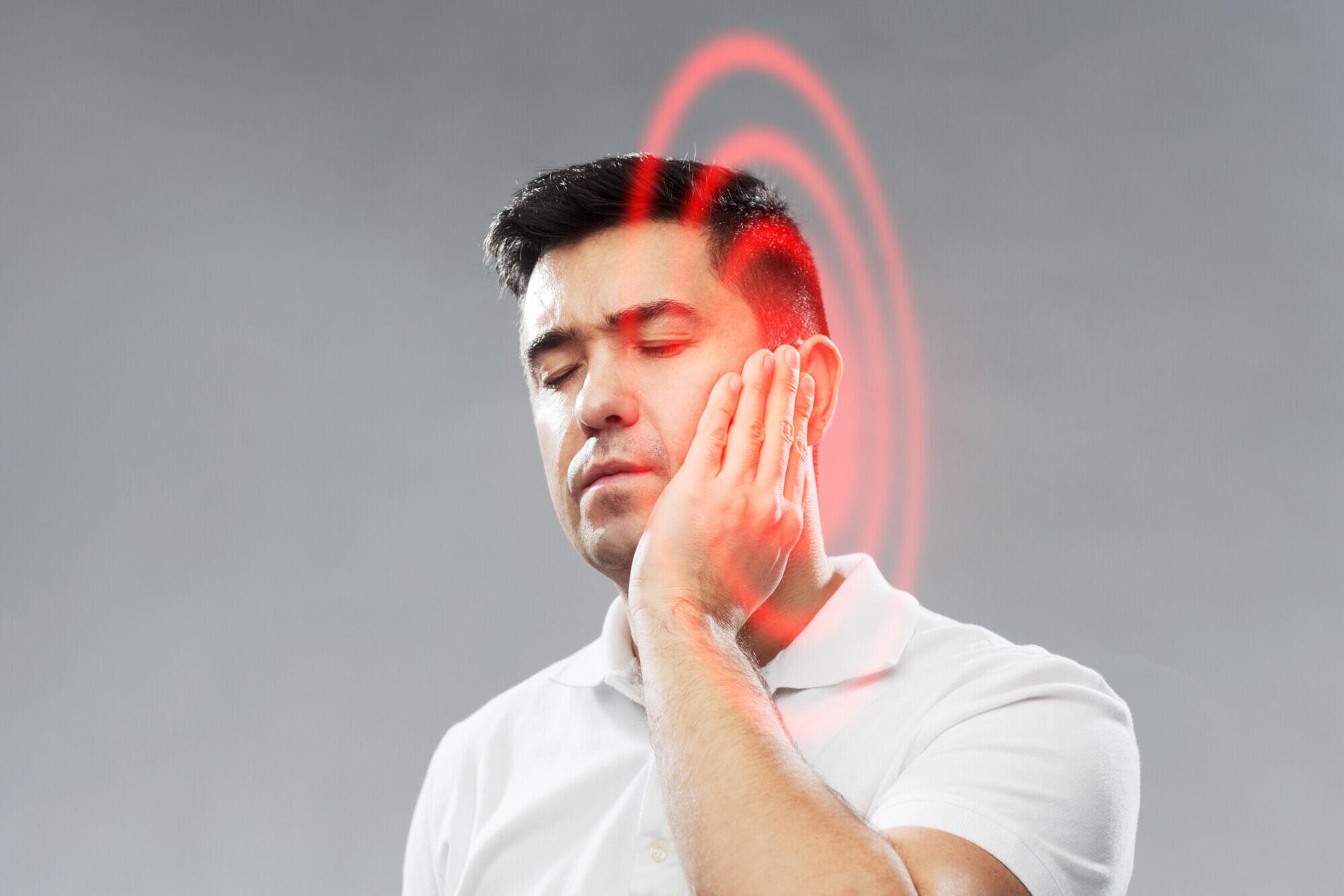 A man is holding his face in pain because of a toothache.