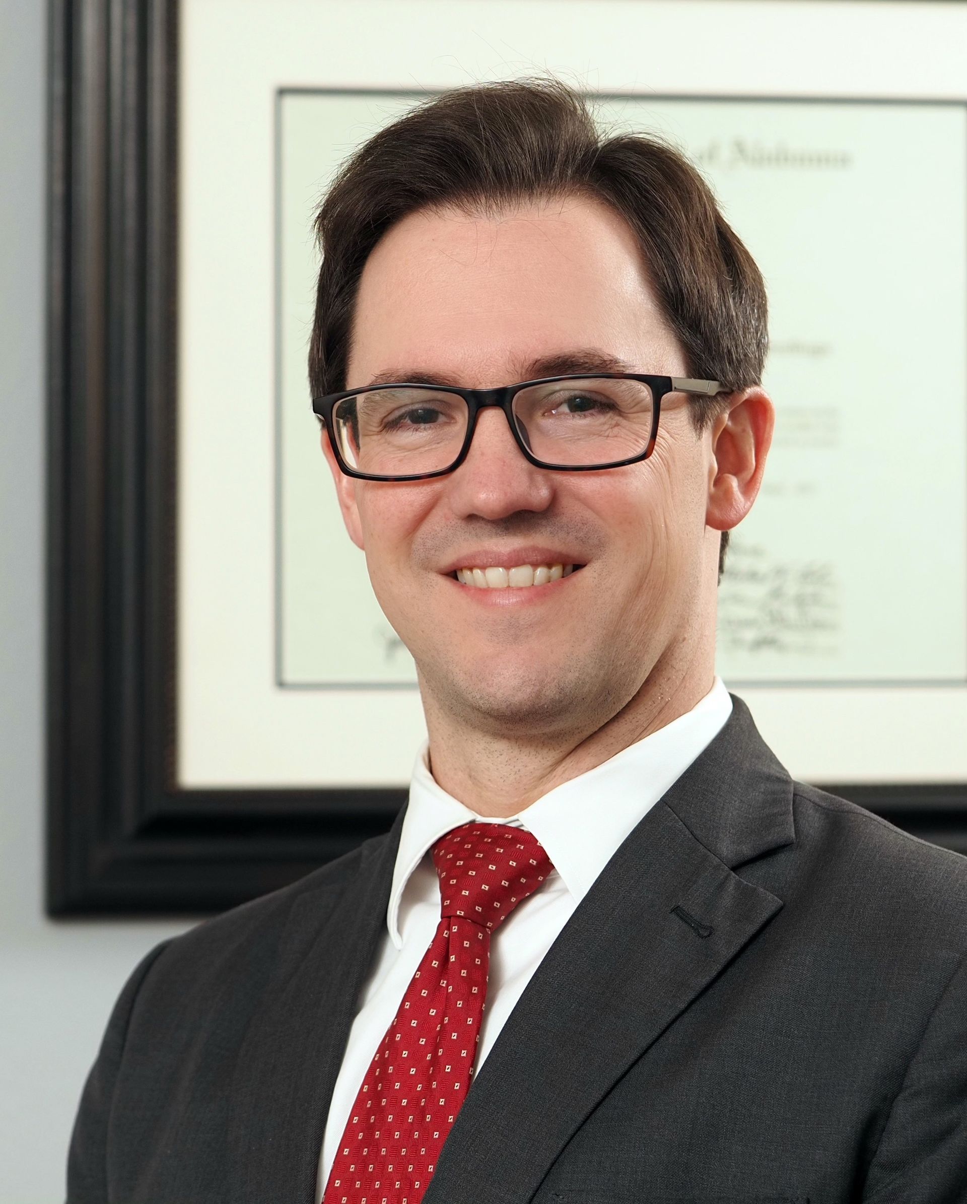 A man in a suit and tie is smiling for the camera