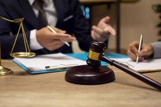 A judge 's gavel is sitting on a table next to a scale of justice.