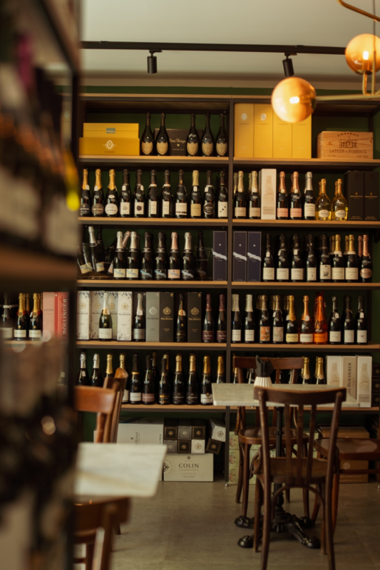 tavoli, sedie e scaffali pieni di bottiglie di vino