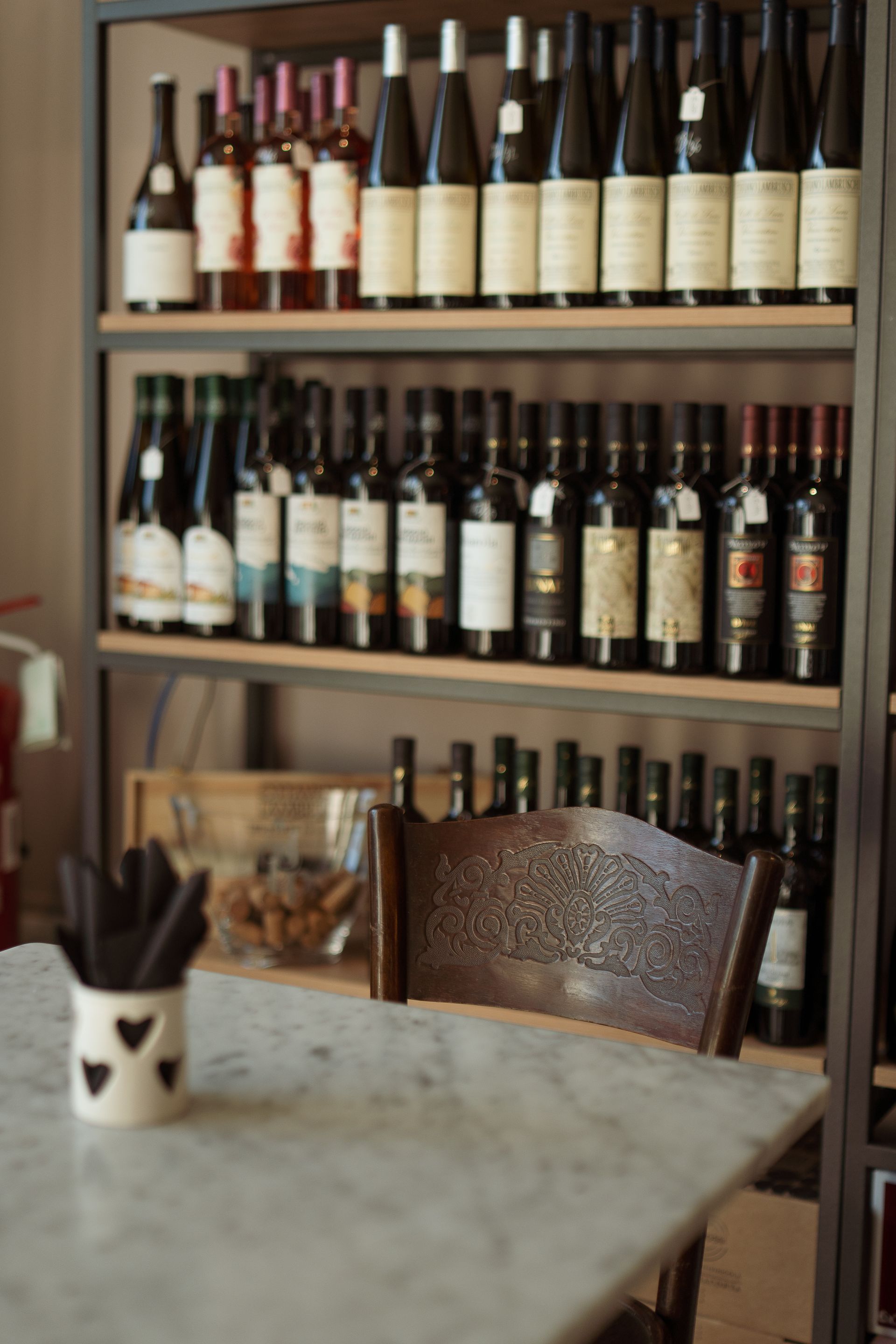 Un tavolo davanti a uno scaffale pieno di bottiglie di vino