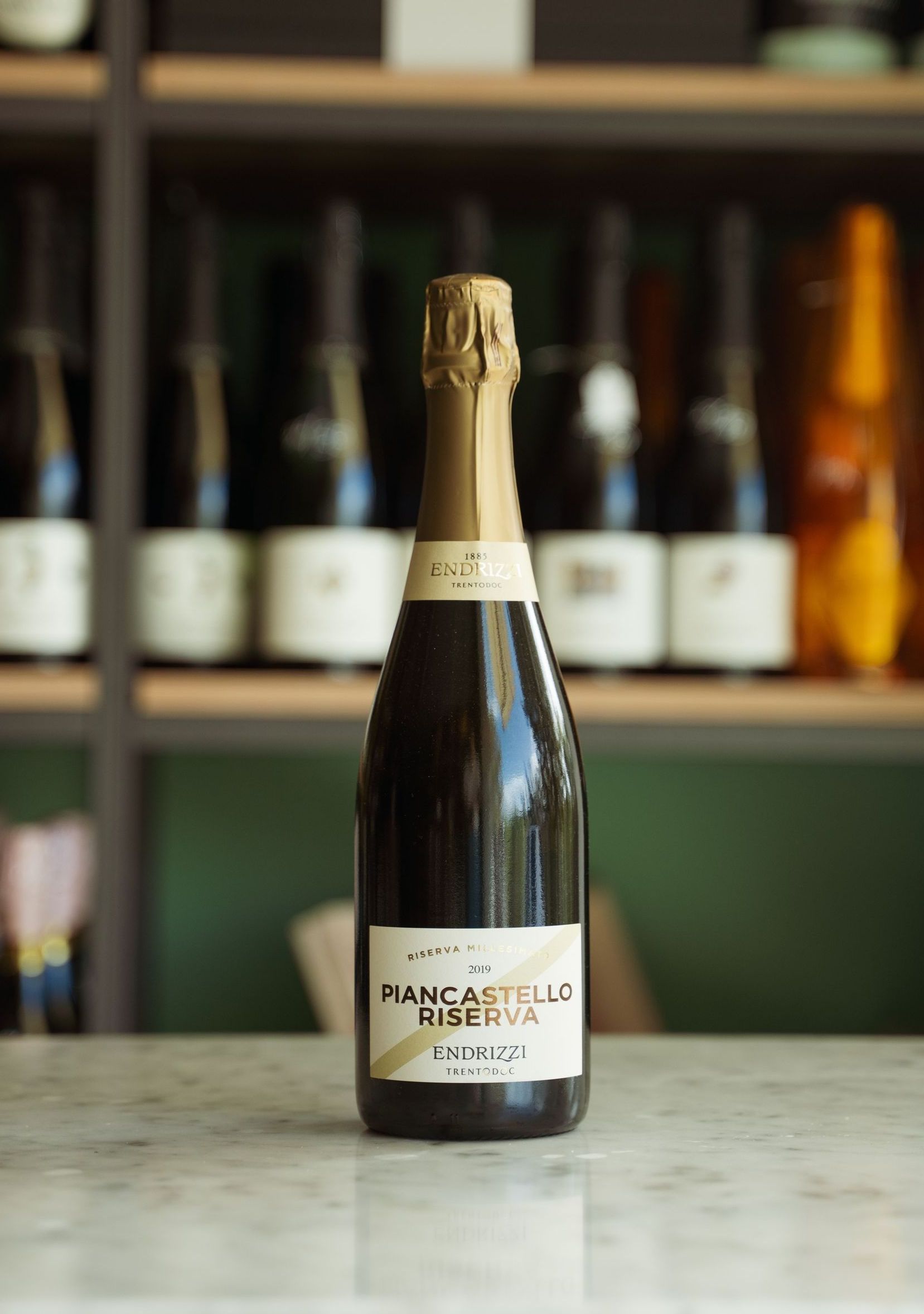 Una bottiglia di spumante è appoggiata su un bancone