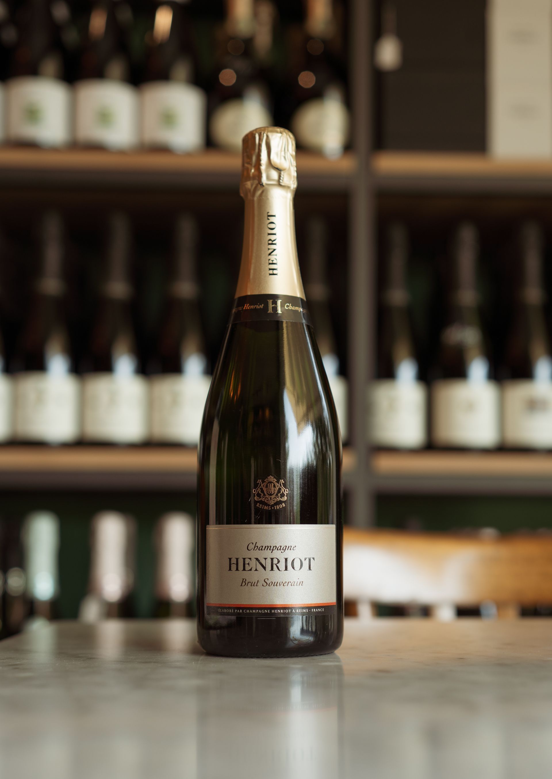 Una bottiglia di champagne Henriette è appoggiata su un tavolo.