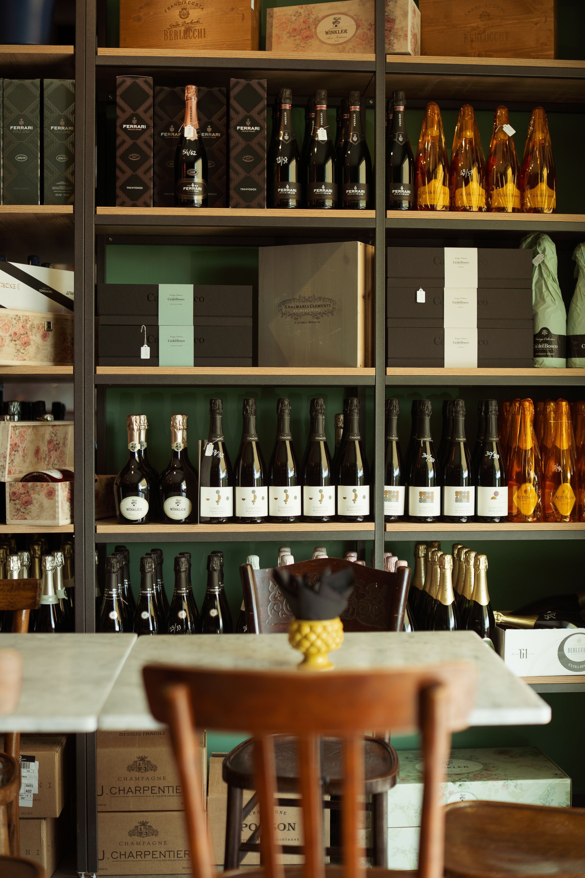 Un tavolo e delle sedie di fronte a uno scaffale pieno di bottiglie di vino.