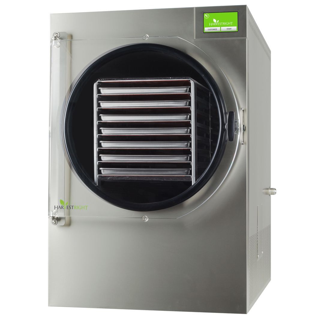 Silver freeze dryer with a round chamber door open, revealing trays. A green digital display is visible on top.