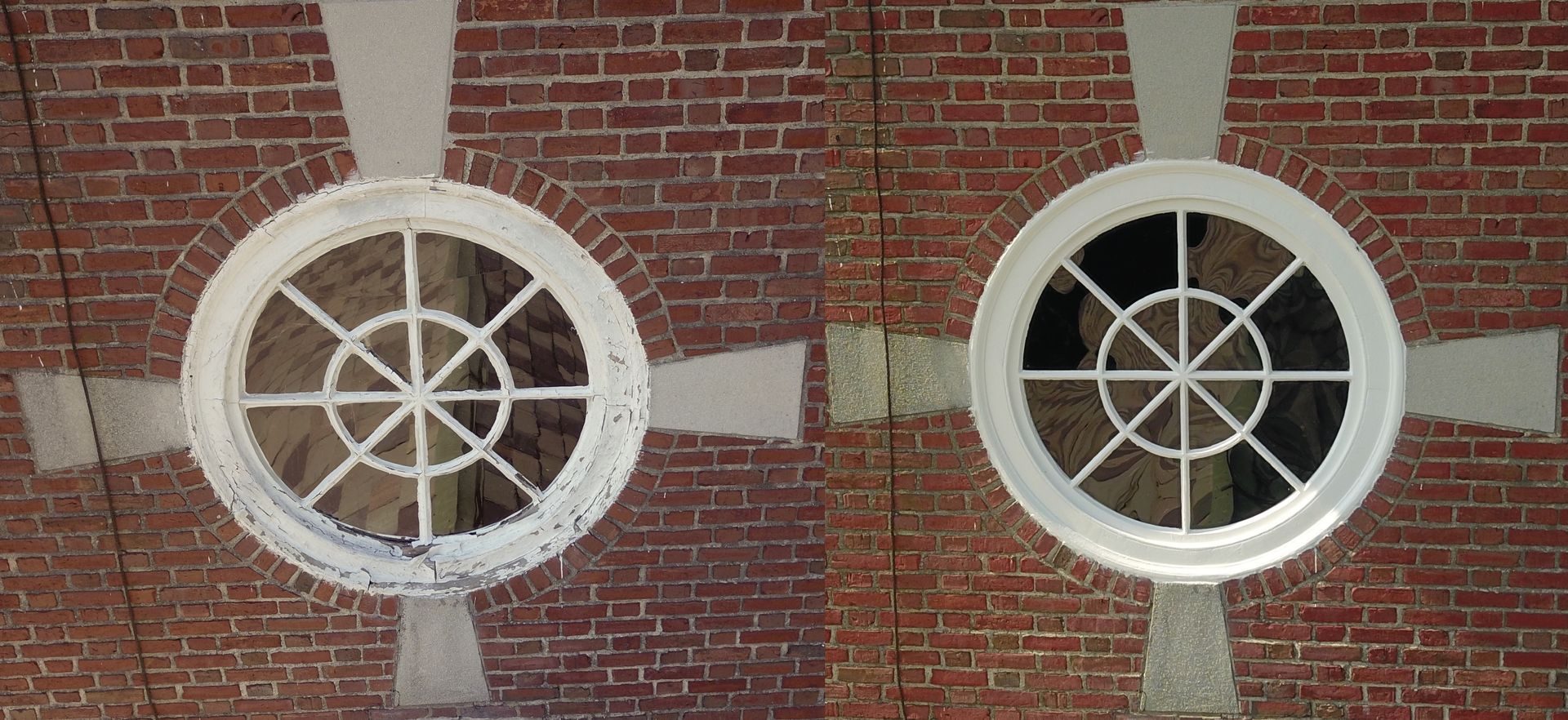 Two circular, white-framed windows with cross-shaped masonry surrounds set into a red brick wall.