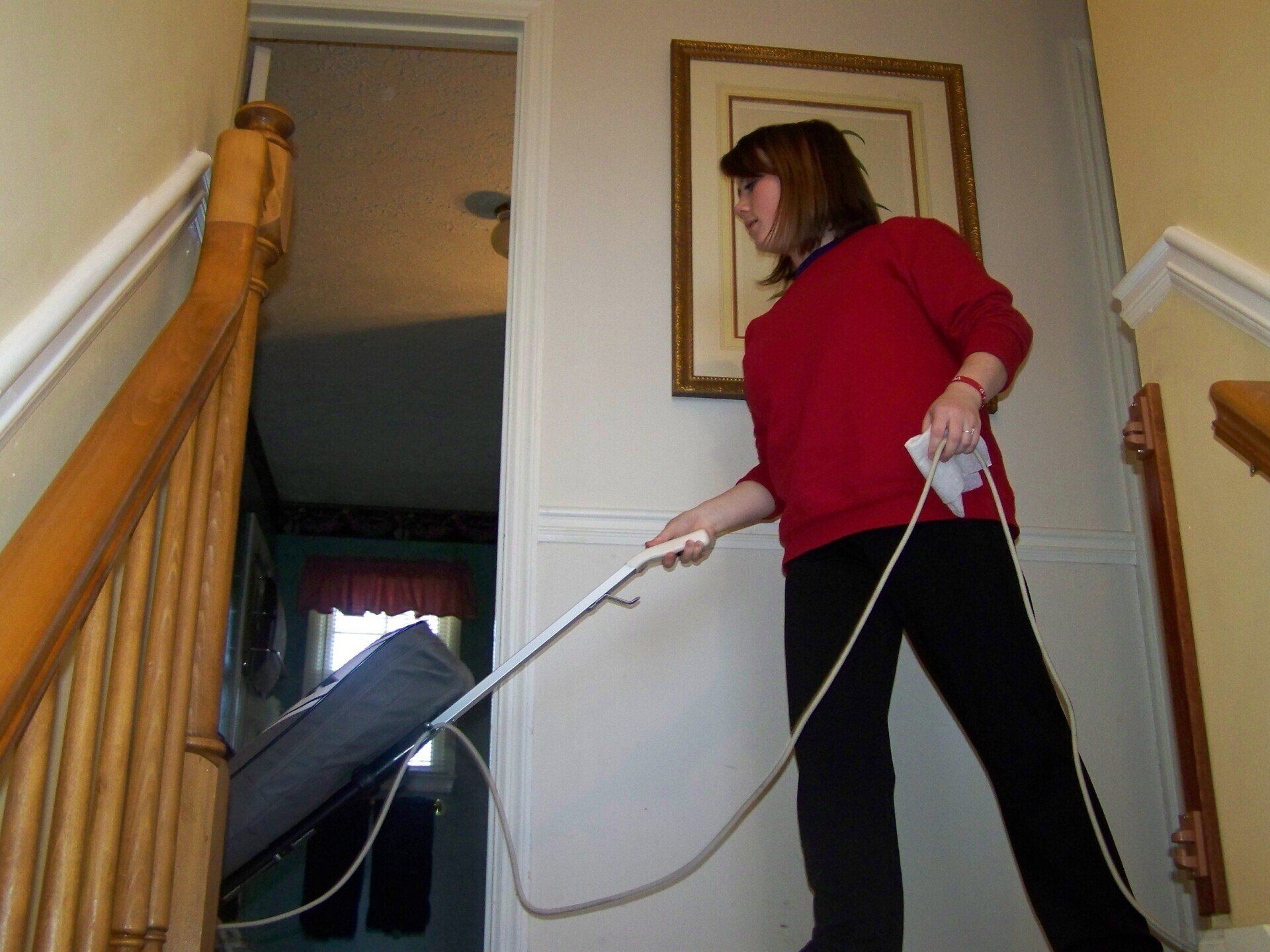 A woman in a red sweater is holding a wii controller