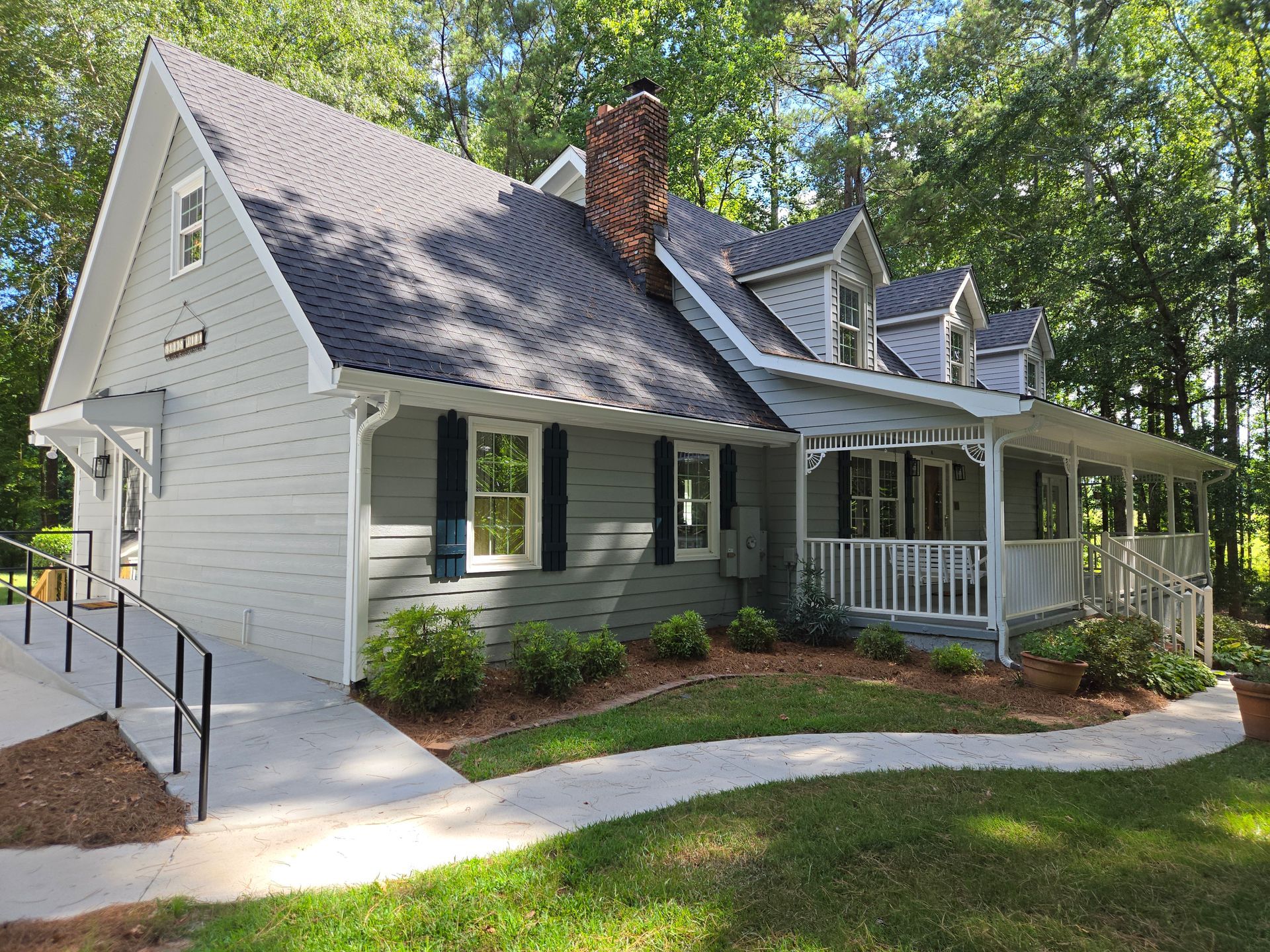 A white house with a black roof and a porch