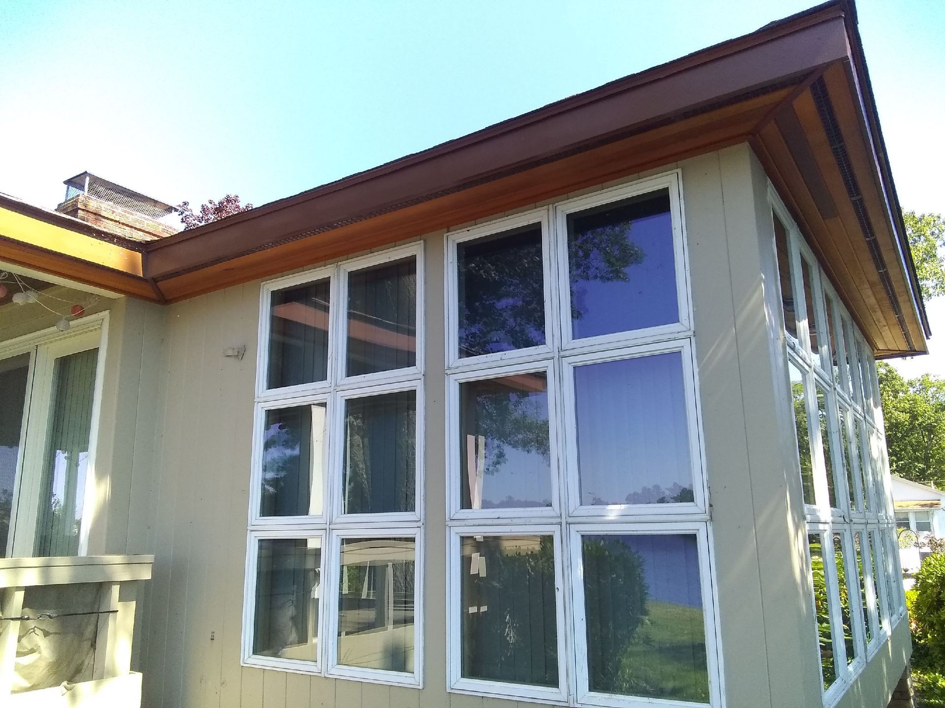 A white deck with stairs leading up to it is in front of a house.