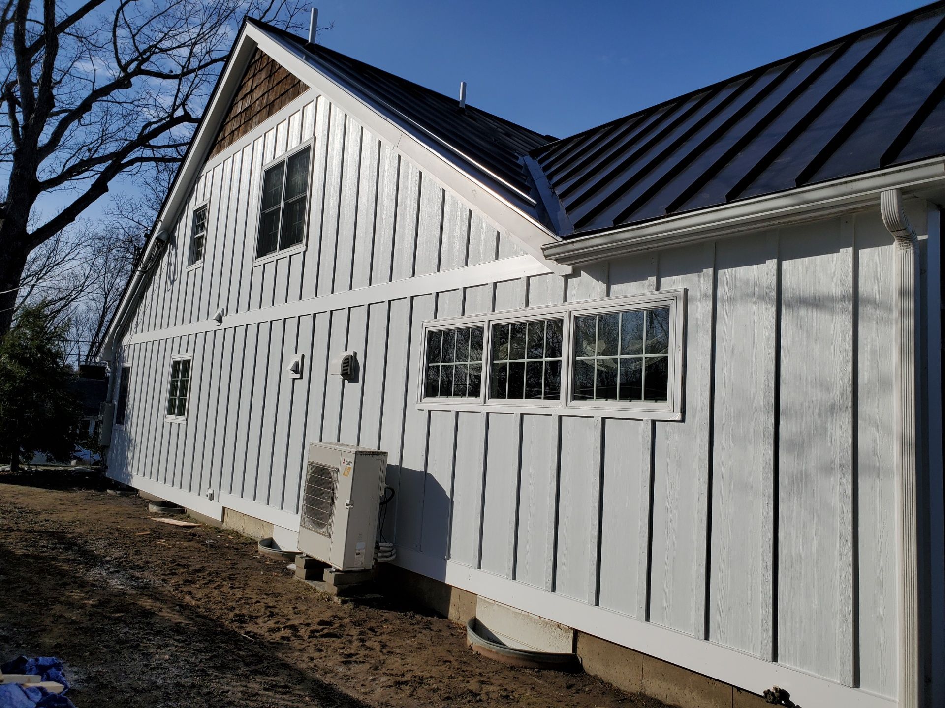 A white house with a black roof and a lot of windows