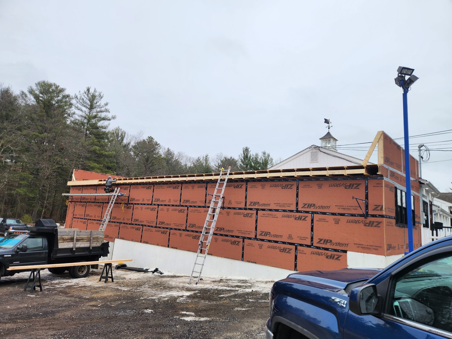 A white deck with stairs leading up to it is in front of a house.