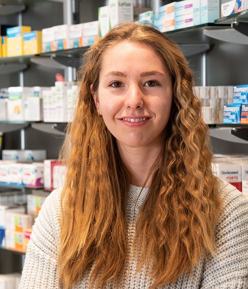 Eine Frau steht vor einem Regal in einer Apotheke.