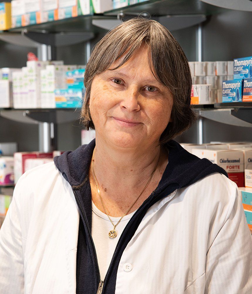 Eine Frau steht vor einem Regal in einer Apotheke.