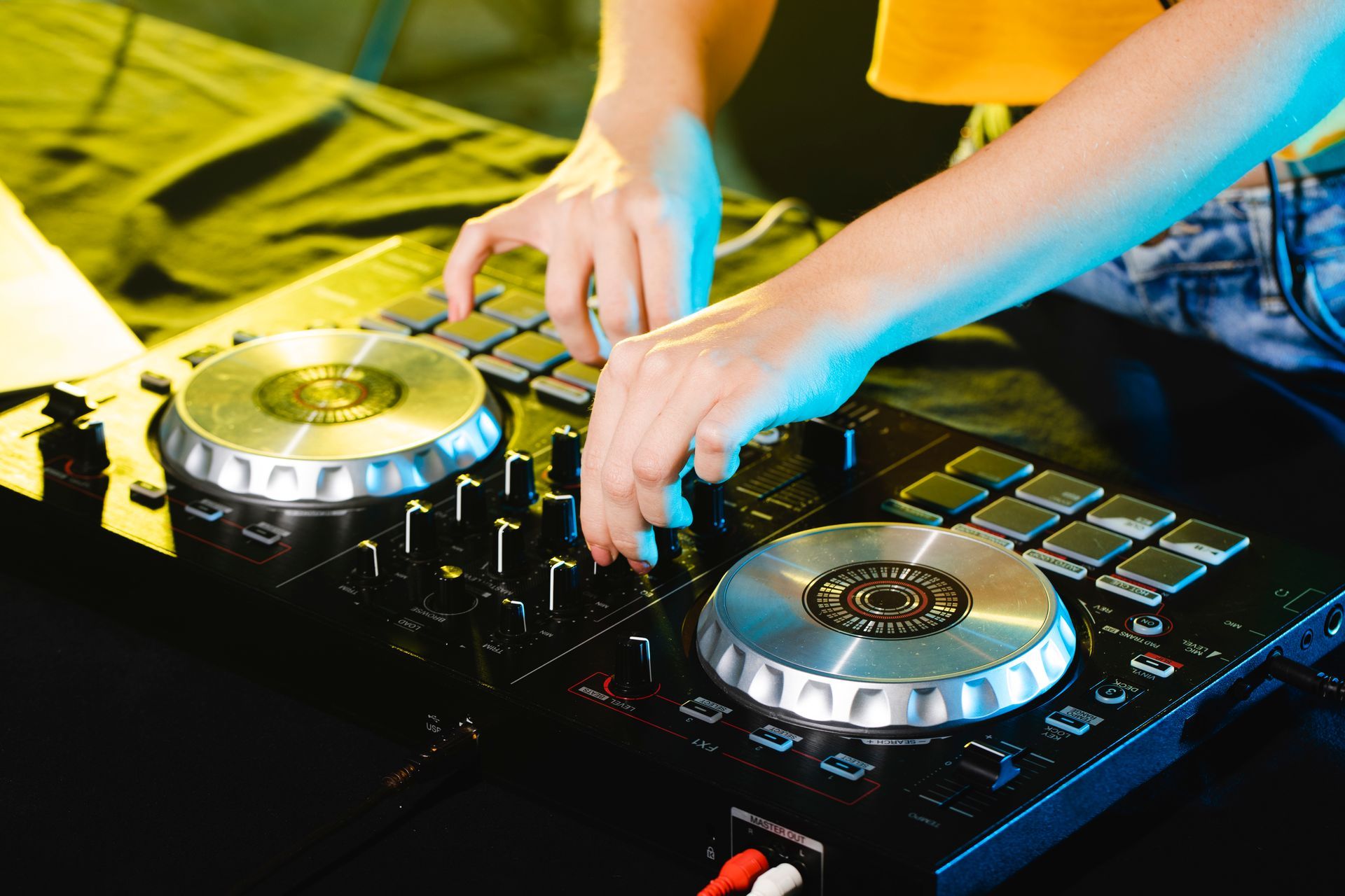 A person is playing music on a DJ controller.