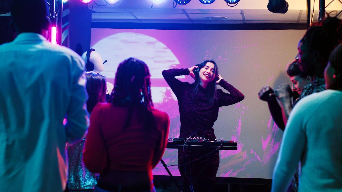 A woman is standing in front of a crowd of people at a party.