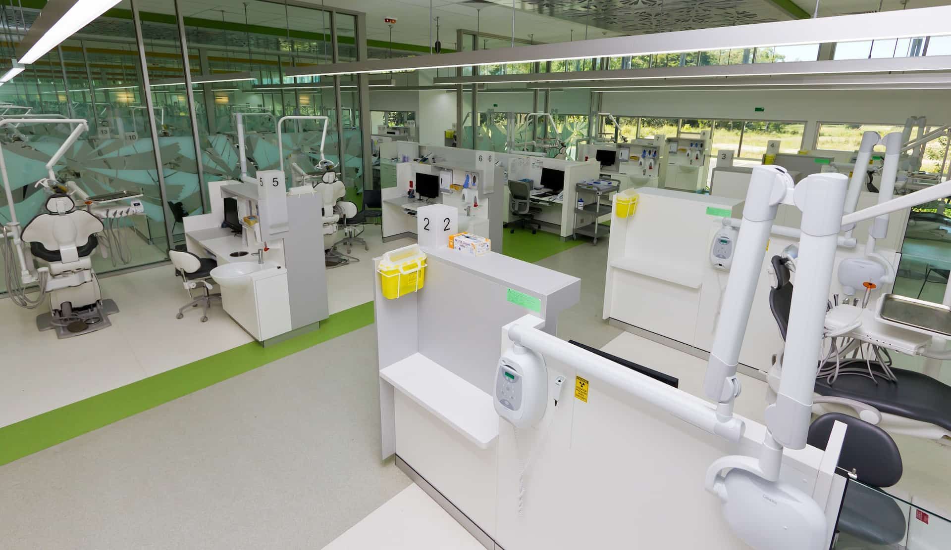 Dental Clinic Interior With Multiple Patient Stations, Equipment, and a Green Floor — JCU Dental In Smithfield, QLD