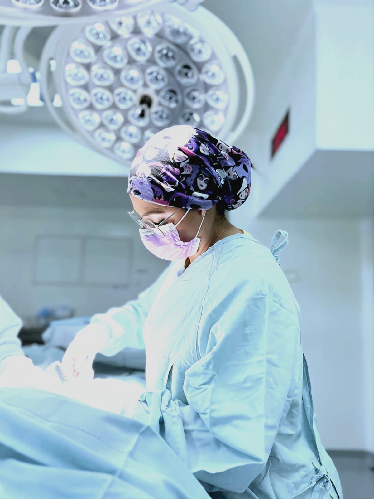 Una cirujana está operando a un paciente en un quirófano.