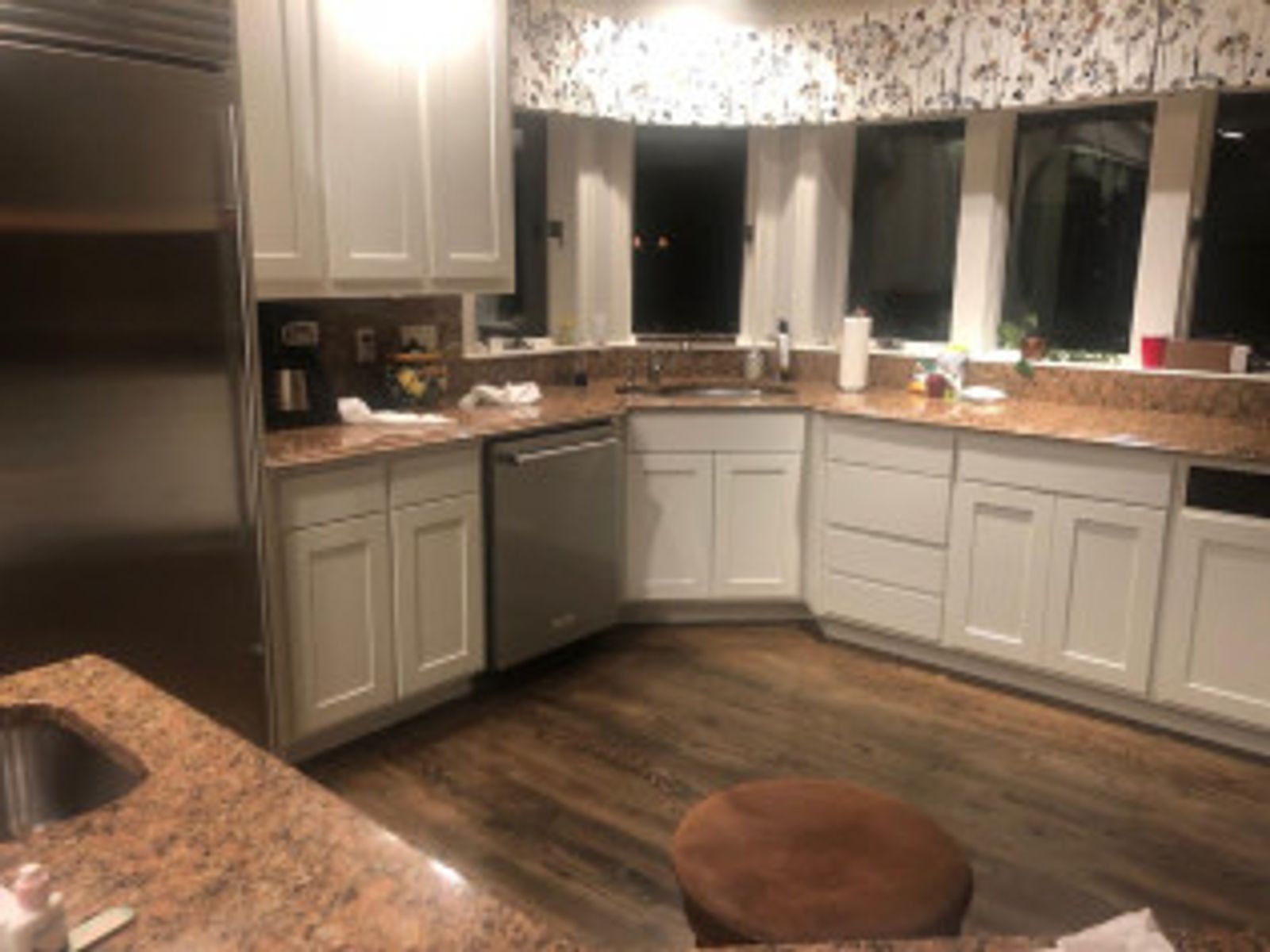 Kitchen with light gray cabinets, granite countertops, dishwasher, and wood-look flooring.