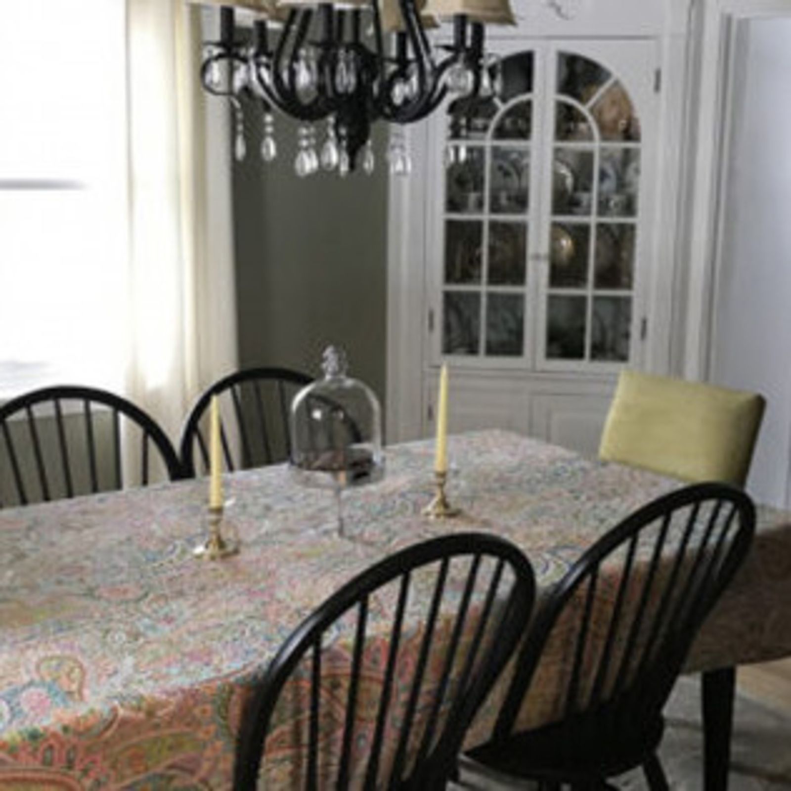Dining room with table, chairs, chandelier, and a white cabinet.
