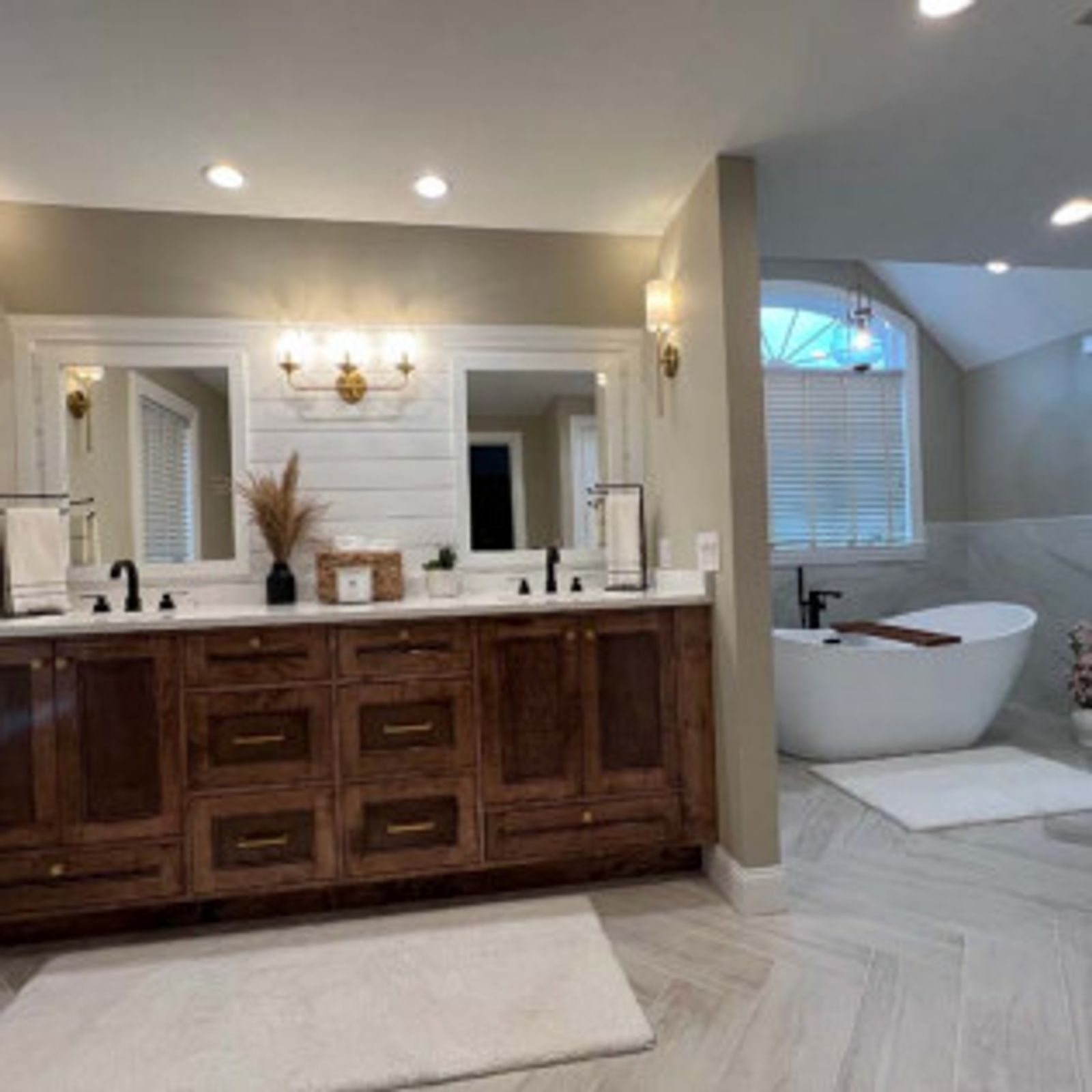 Elegant bathroom with double vanity, free-standing tub, neutral colors, and wood accents.