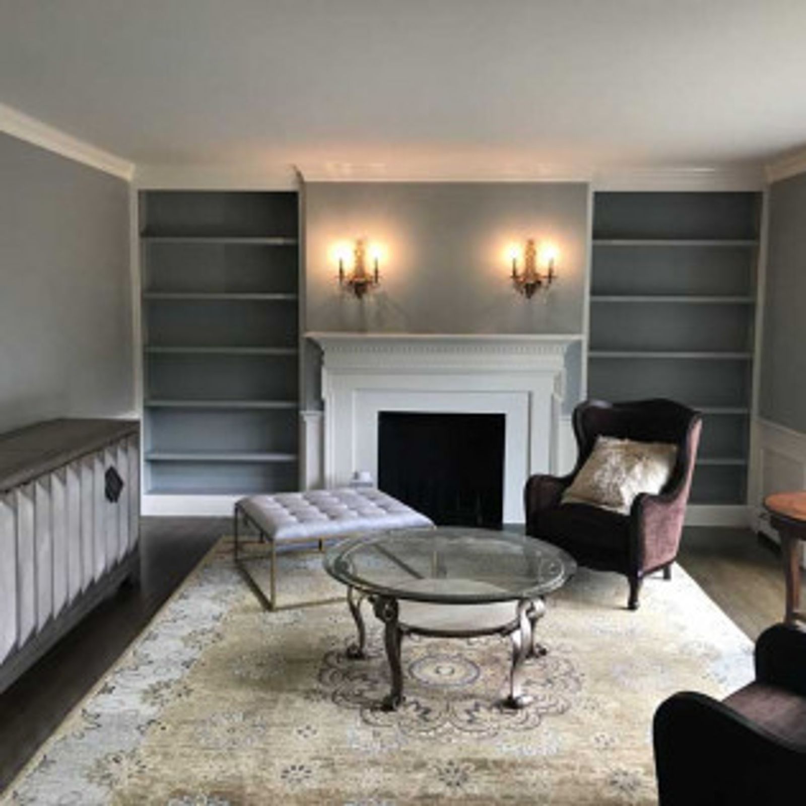 Living room with fireplace, built-in bookshelves, seating, rug, and coffee table.