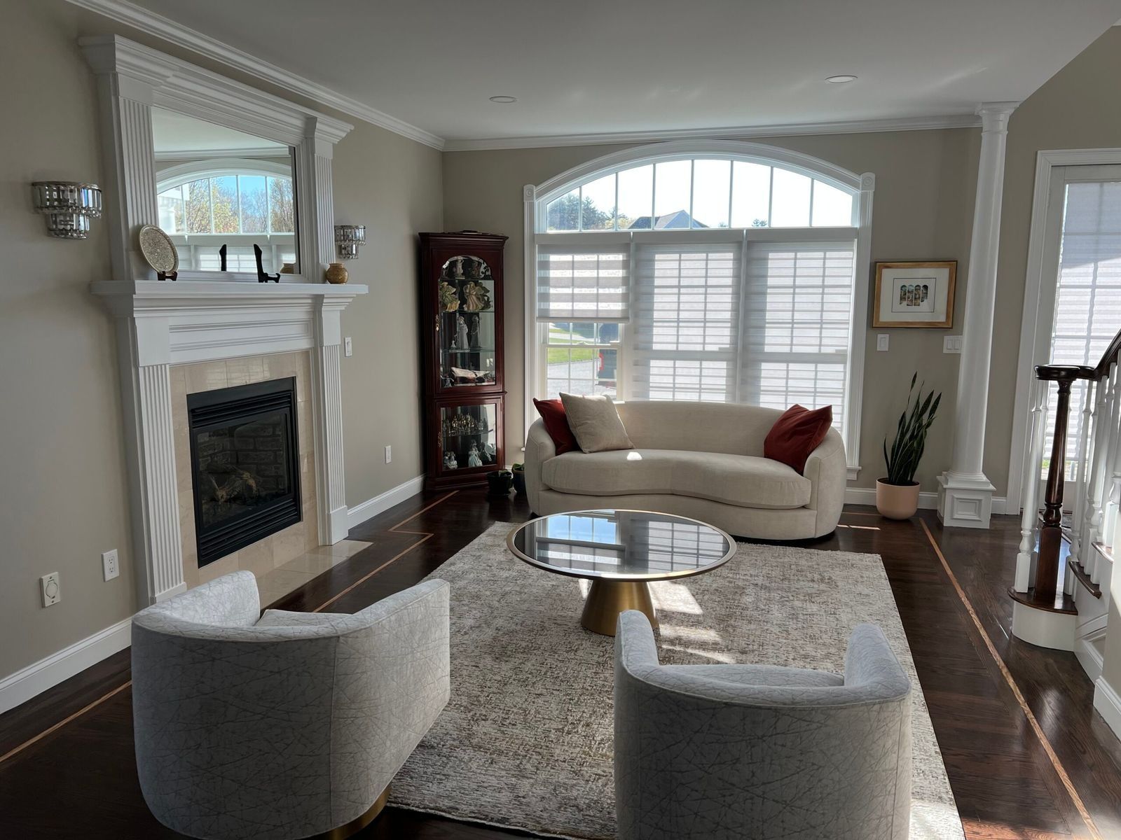 Living room with fireplace, sofa, chairs, and round coffee table on a rug.