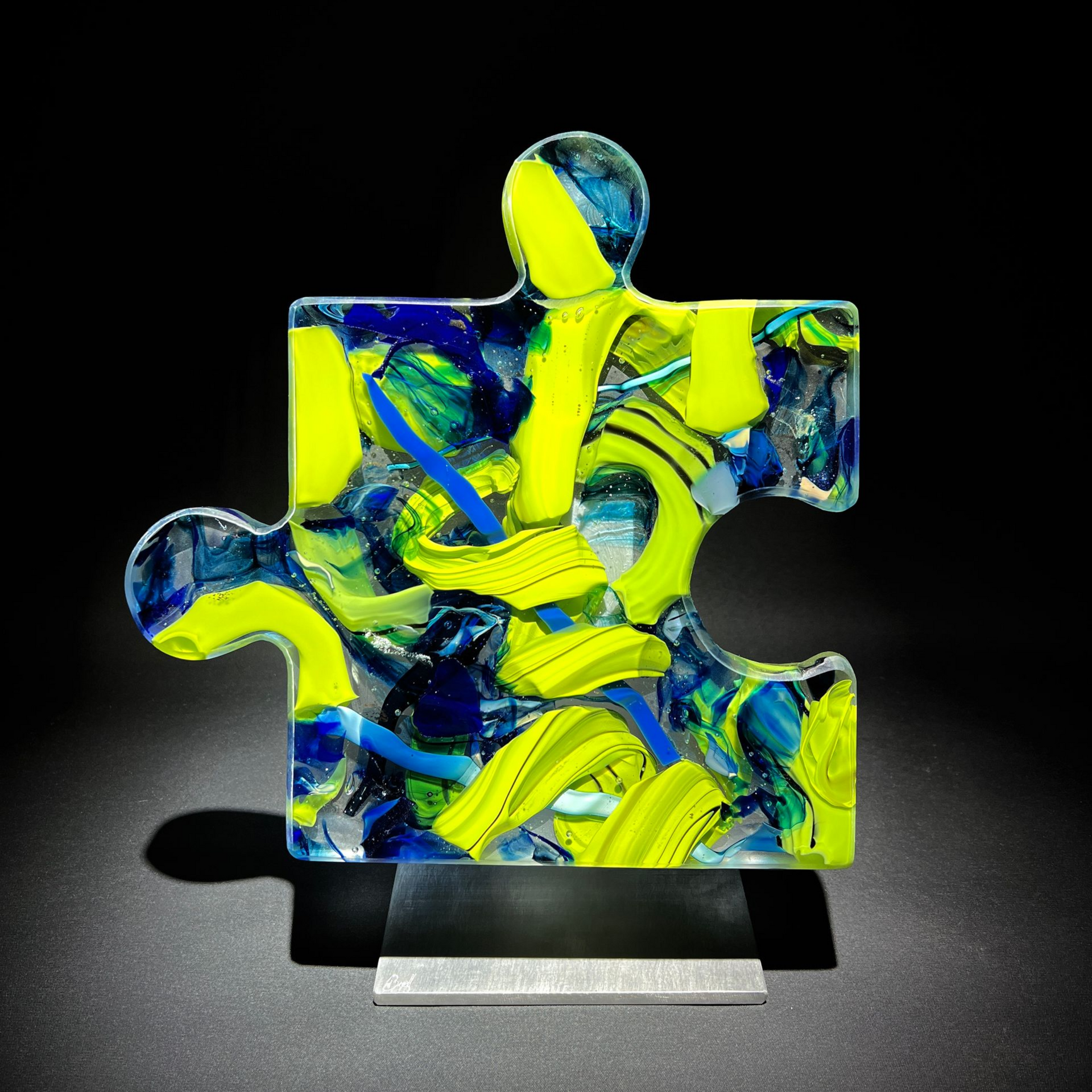 A colorful puzzle piece is sitting on a black surface