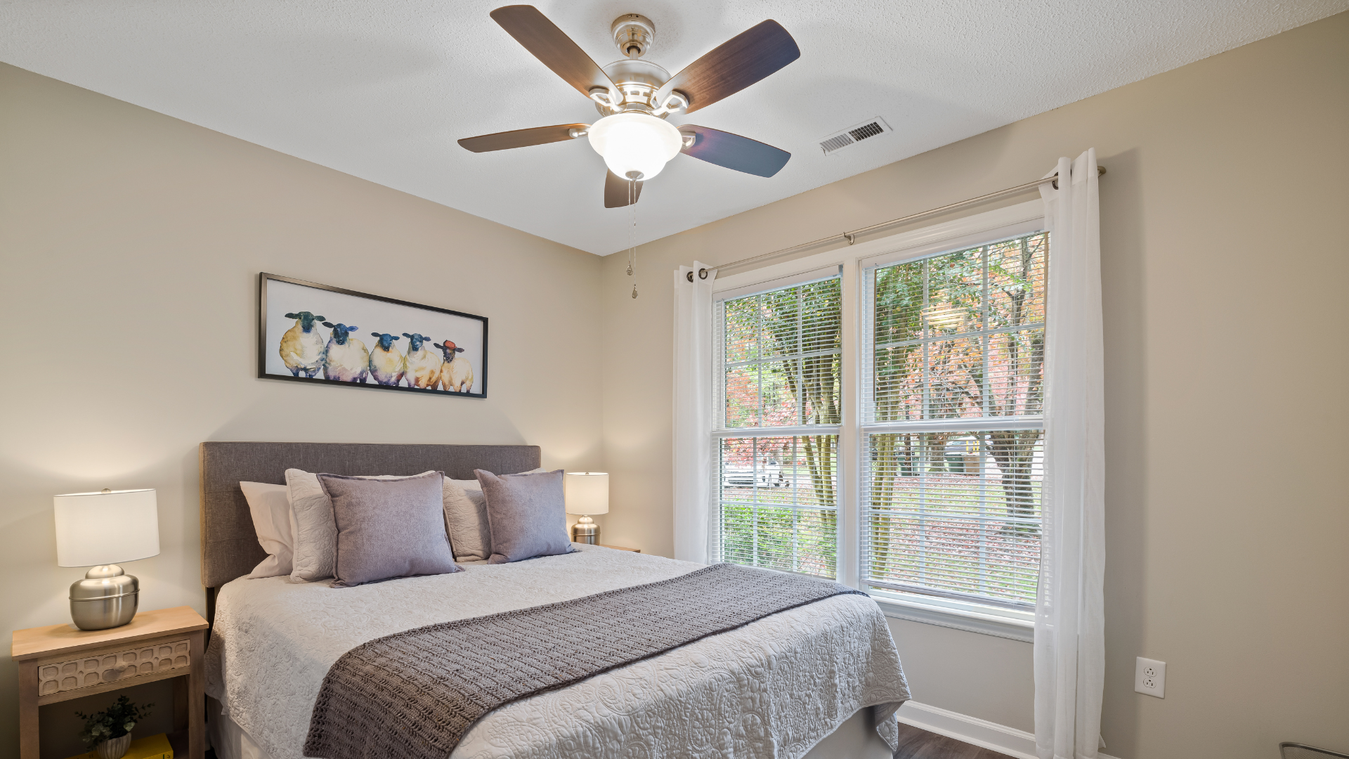 A bedroom with a bed , ceiling fan , and window.