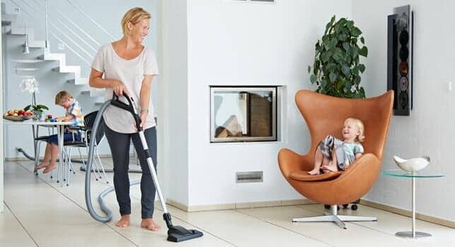 Lady cleaning the house using vacuum — central vacuum system in Mobile, AL