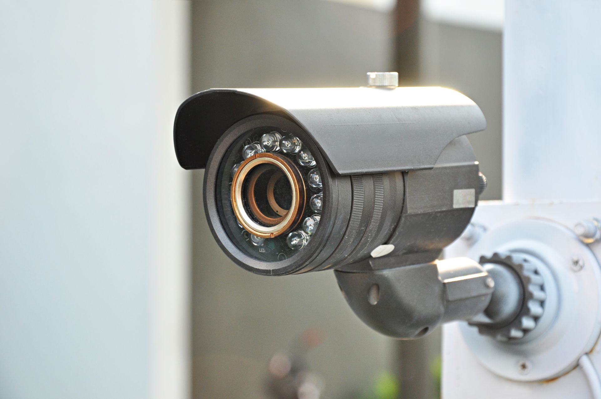 Outdoor security camera mounted under a roof for surveillance and property protection.