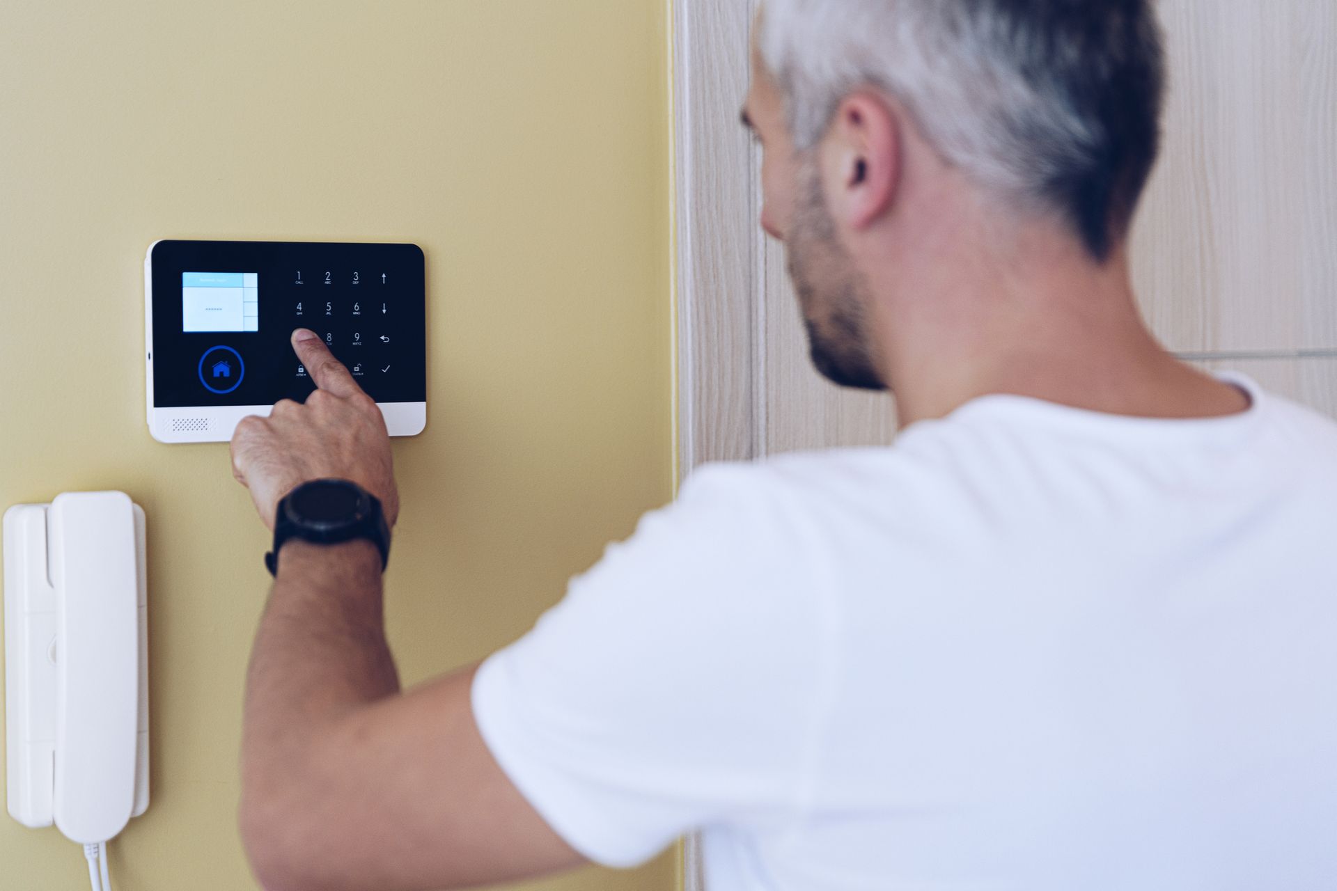 Person using a home security system. Person using a home security system.