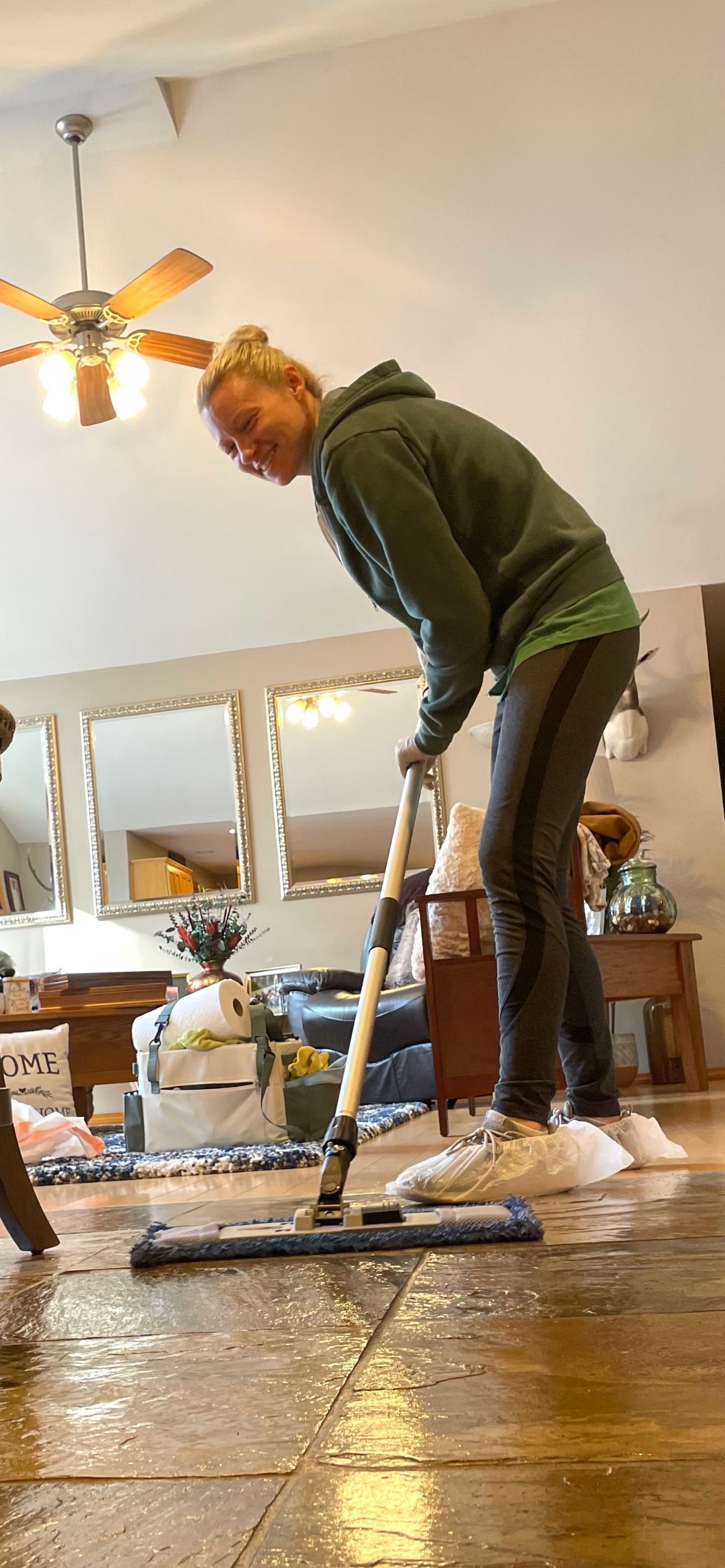 a woman is cleaning the floor with a mop in a living room for house cleaning in Sumner