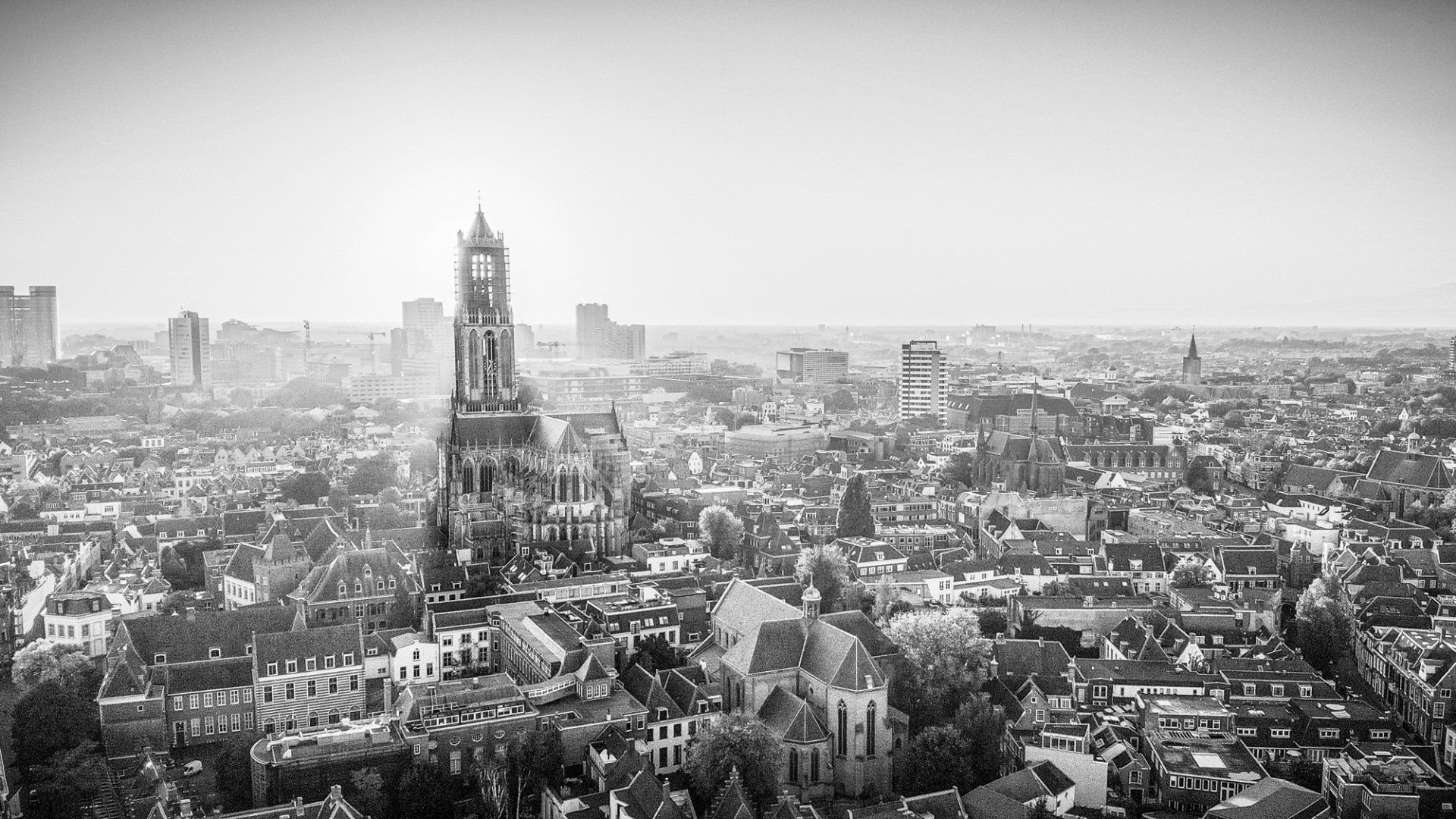 Zwart-wit luchtfoto van de historische skyline van Amersfoort, Nederland, met de centrale Onze Lieve Vrouwetoren.