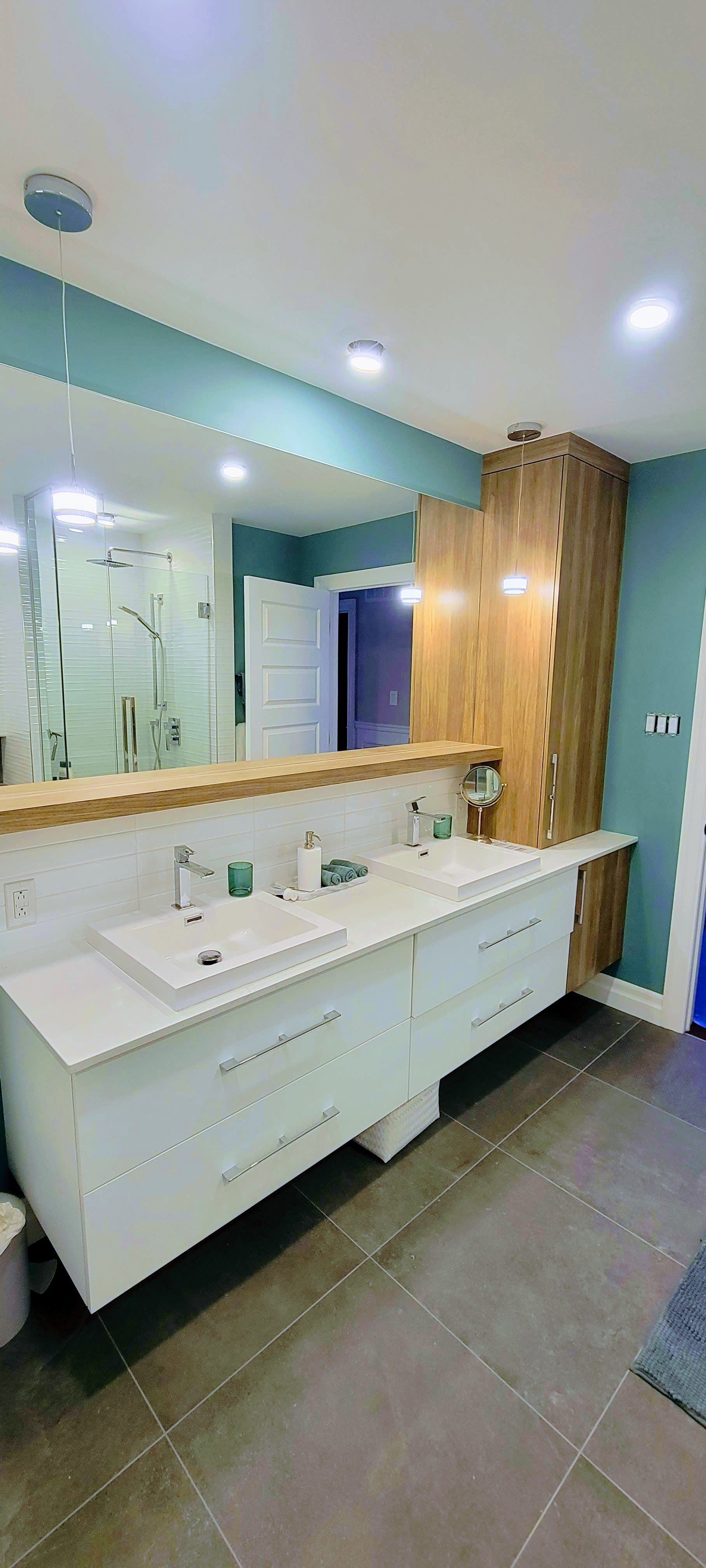 Une salle de bain avec deux lavabos et un grand miroir.