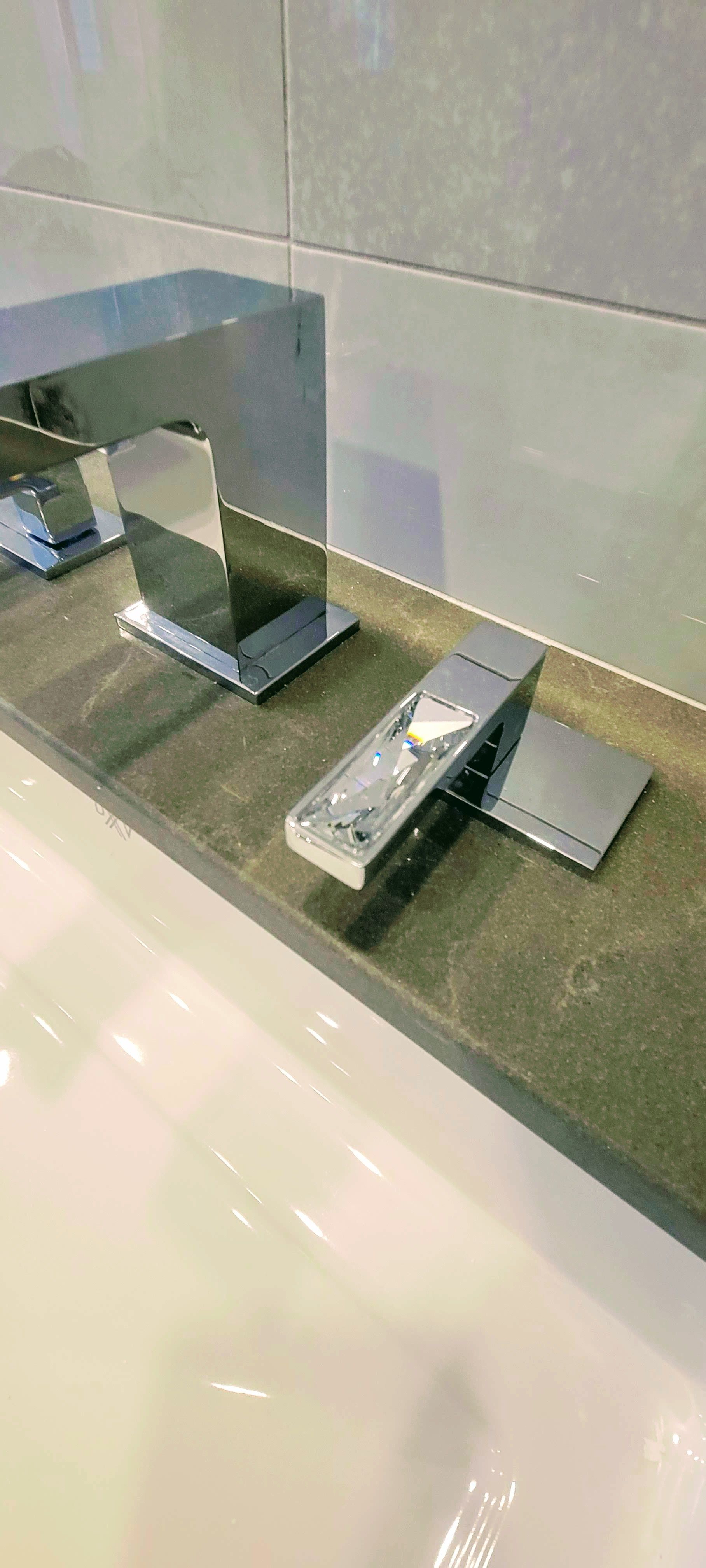 Un gros plan d'un lavabo de salle de bain avec deux robinets dessus.