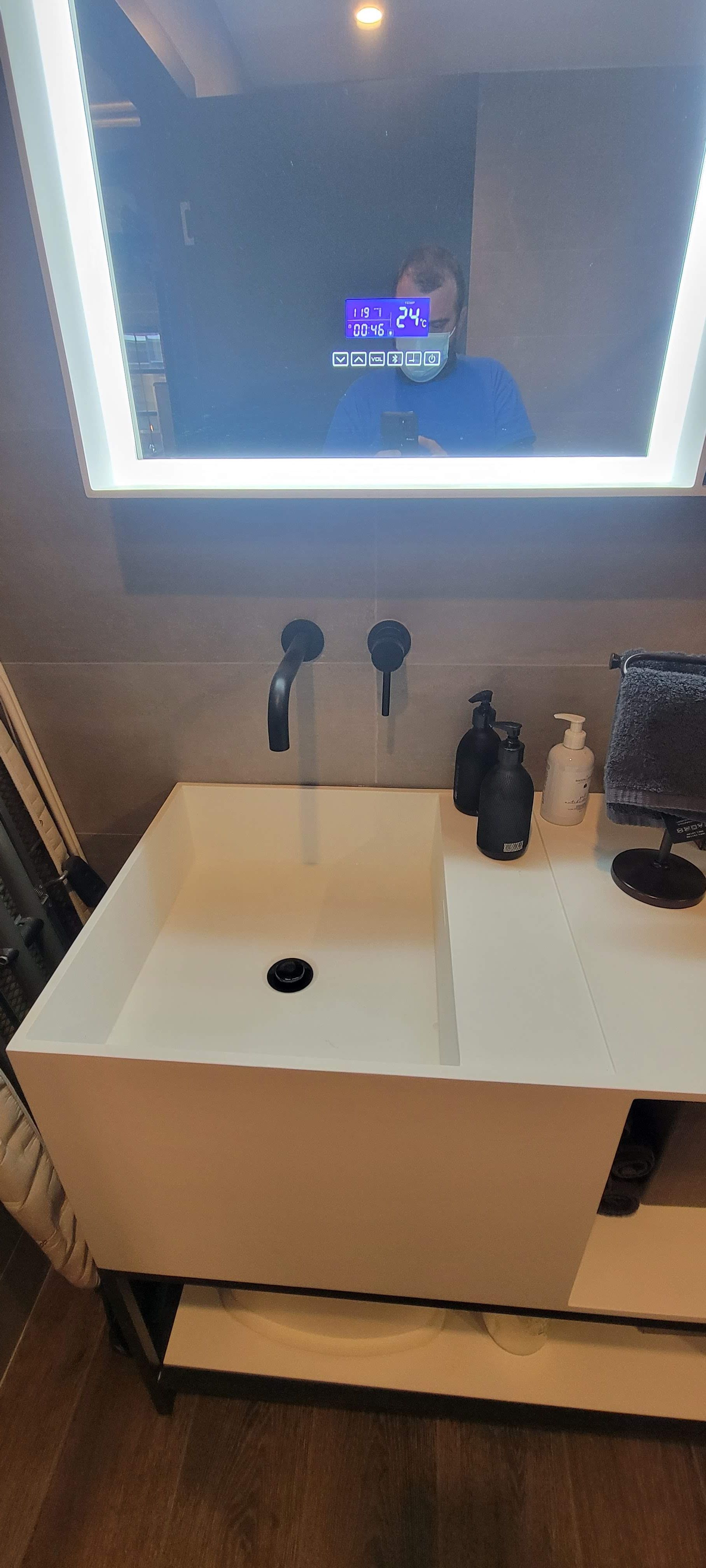 Une salle de bain avec un lavabo et un miroir.