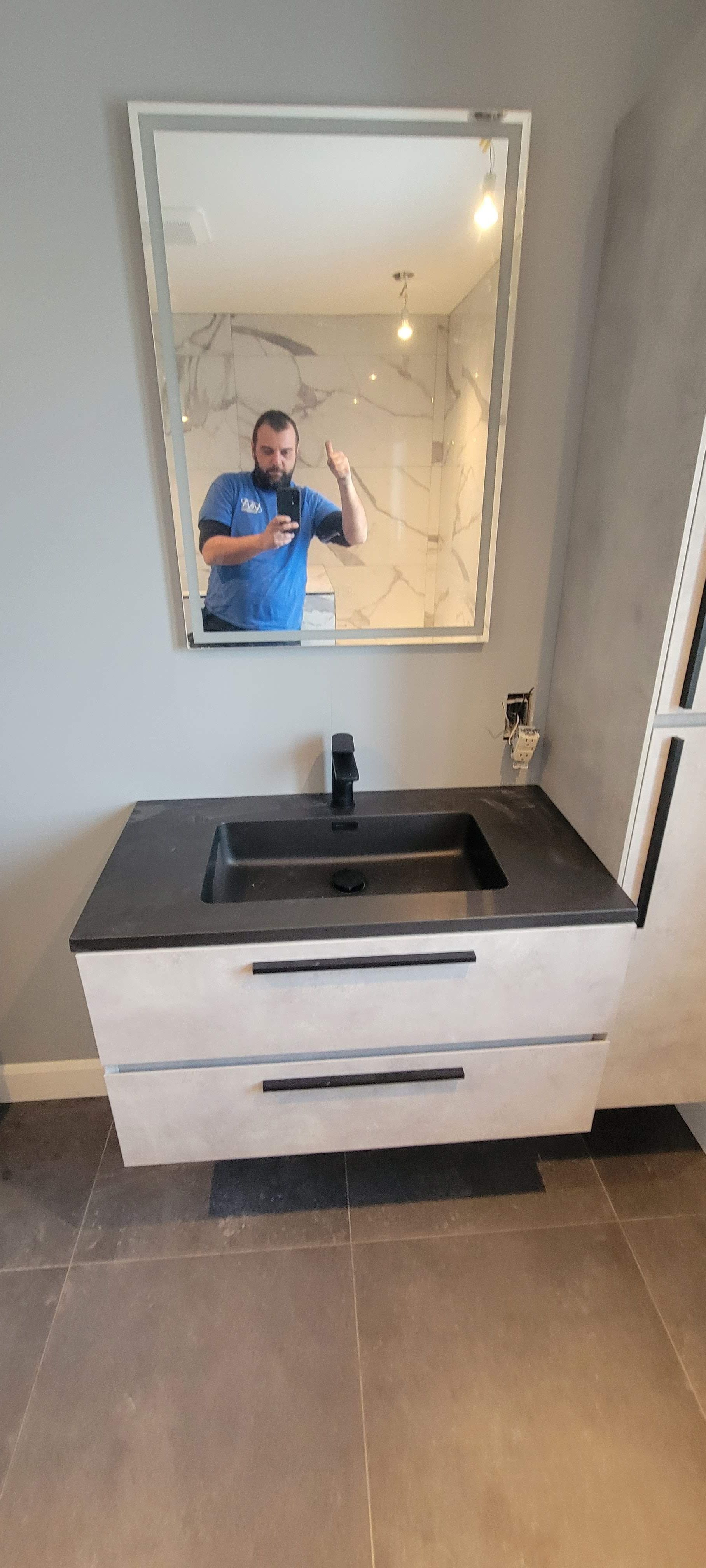Un homme se prend en photo dans un miroir de salle de bain.