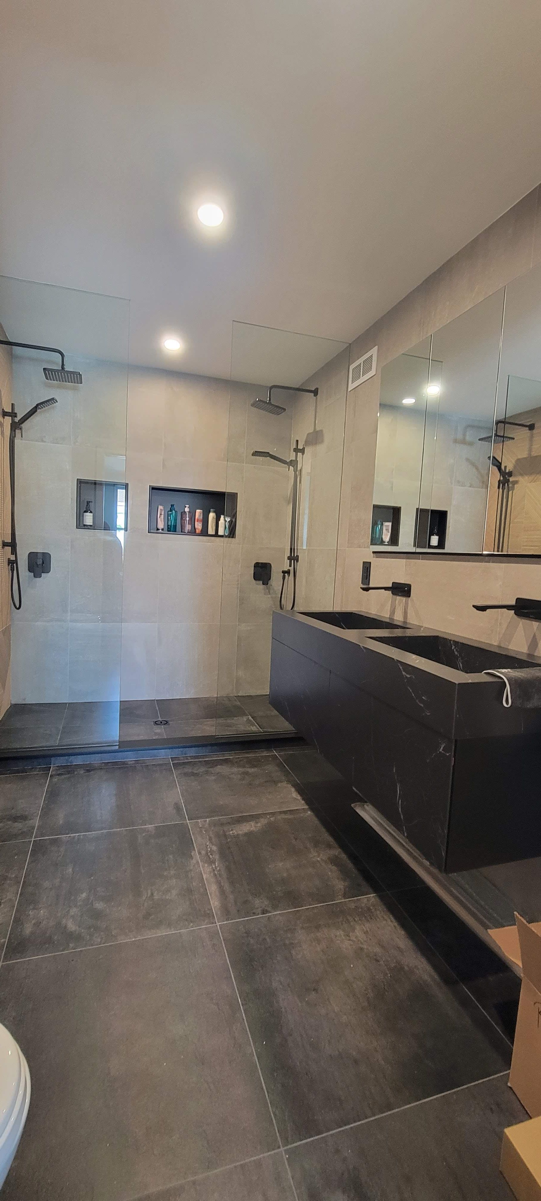 Une salle de bain avec deux vasques et une douche à l'italienne.