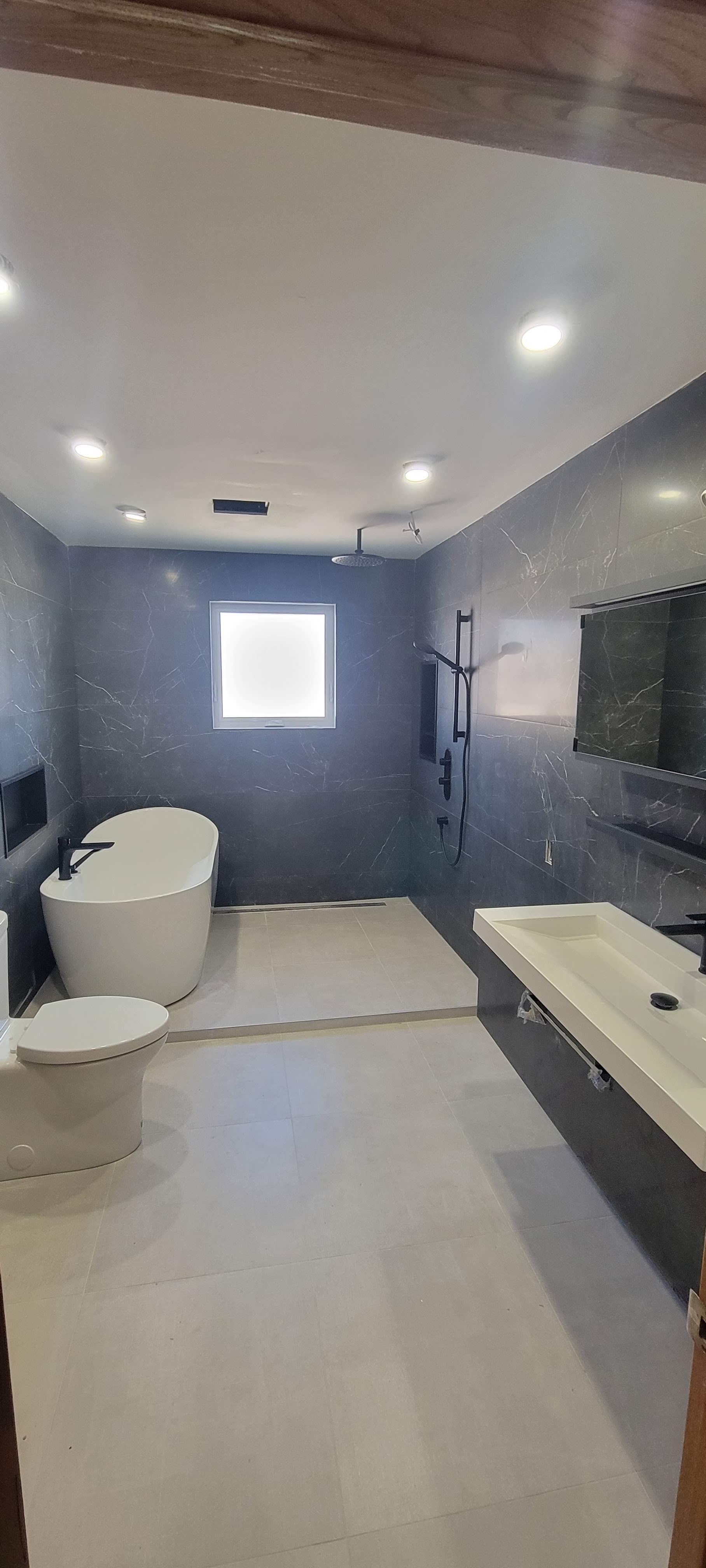 Une salle de bain avec baignoire, lavabo, toilettes et fenêtre.