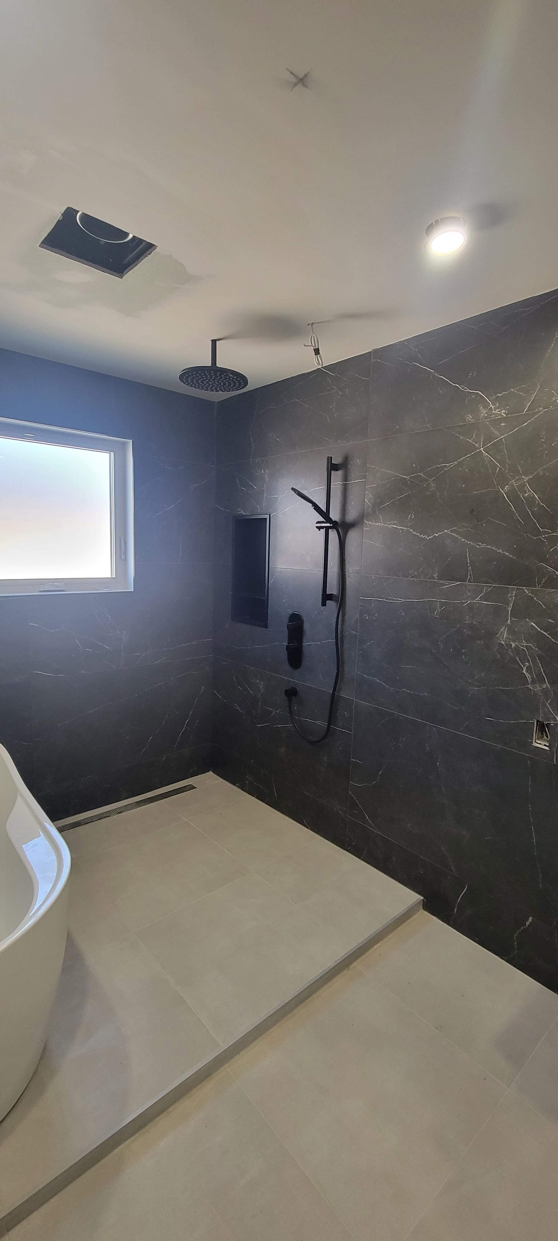 Une salle de bain avec baignoire et pommeau de douche.