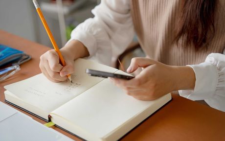 student doing exam hand holding pencil